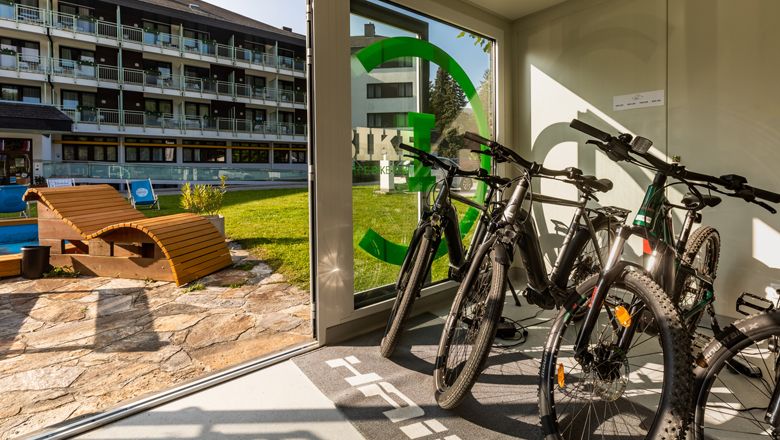 Elektrokola v půjčovně s výhledem do hotelové zahrady.