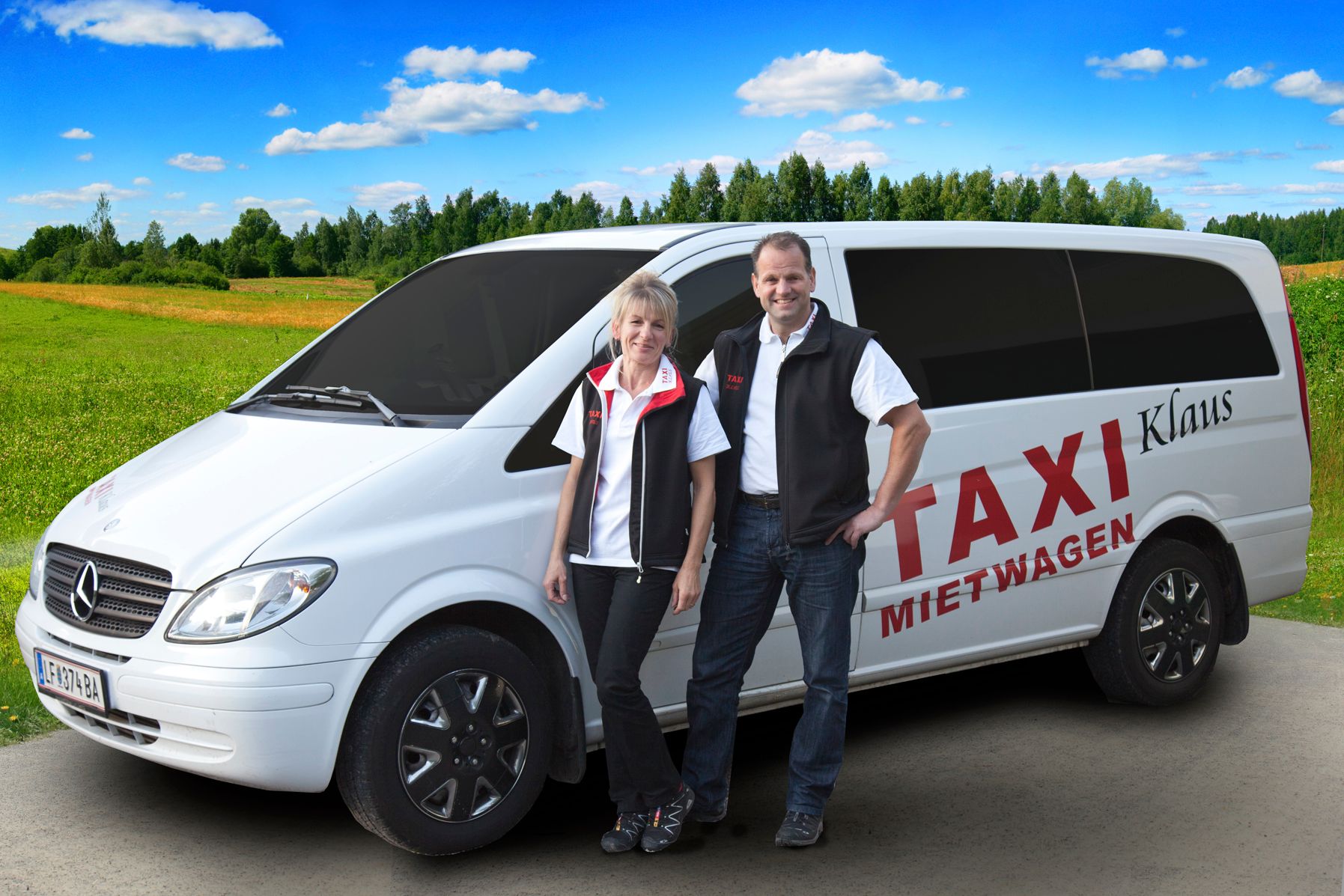 Na venkovské silnici stojí dva lidé před bílou dodávkou Mercedes s nápisem "Taxi Mietwagen Klaus".