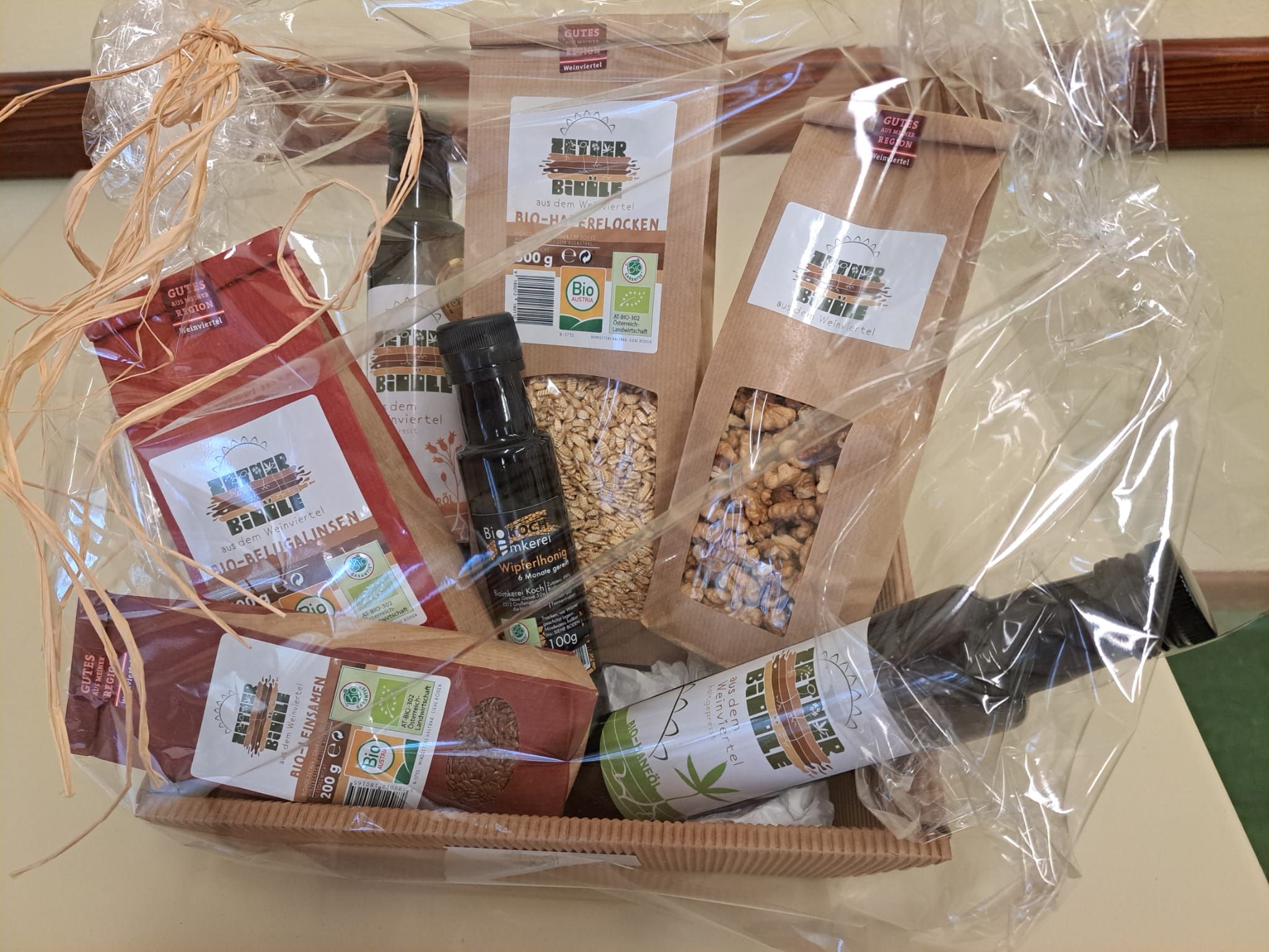 Dárkový koš s bioprodukty, jako je olej, med a obilné vločky.