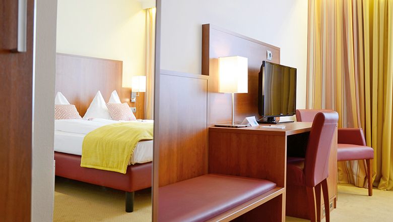 Dvoulůžkový pokoj v hotelu Wachauerhof s postelí, psacím stolem, TV a židlí.