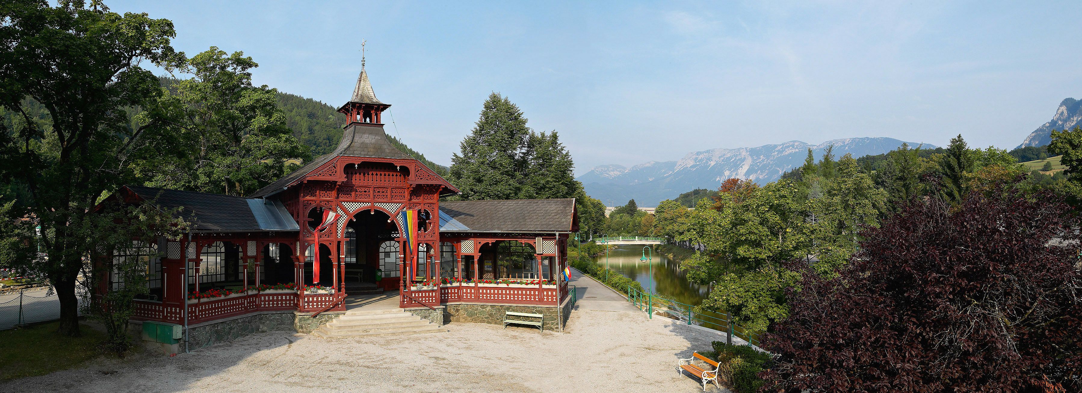 Červený pavilon v Payerbachu s horami v pozadí.