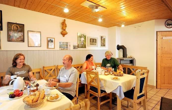 Snídaně se podává v útulné místnosti s dřevěným nábytkem a dekoracemi na stěnách.