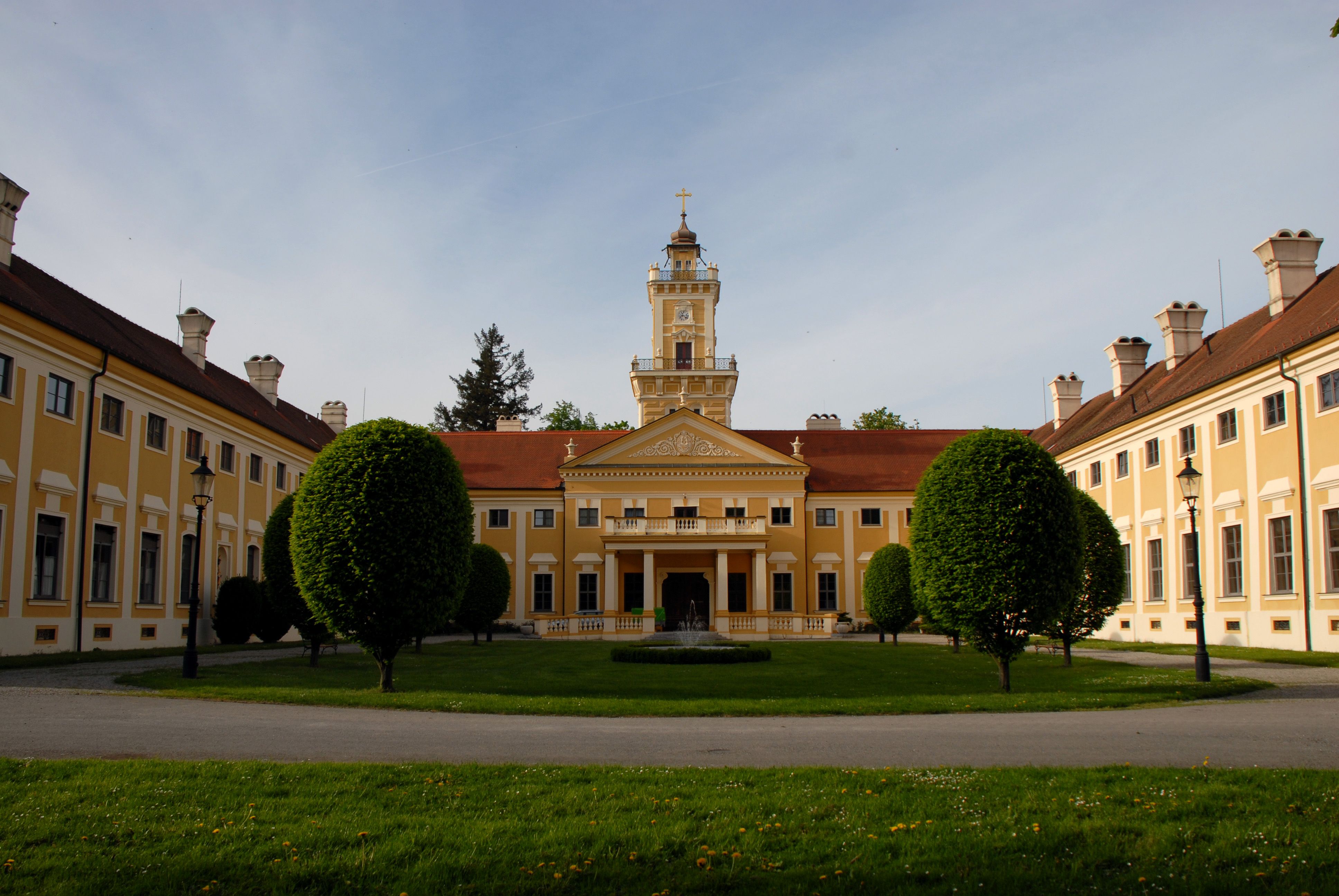 Zámek Jaidhof se žlutou fasádou a věží, obklopený udržovanou zahradou.