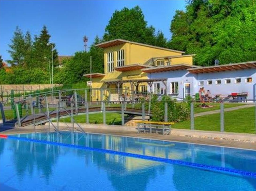 Venkovní bazén Altlengbach s bazénem a budovou v pozadí.
