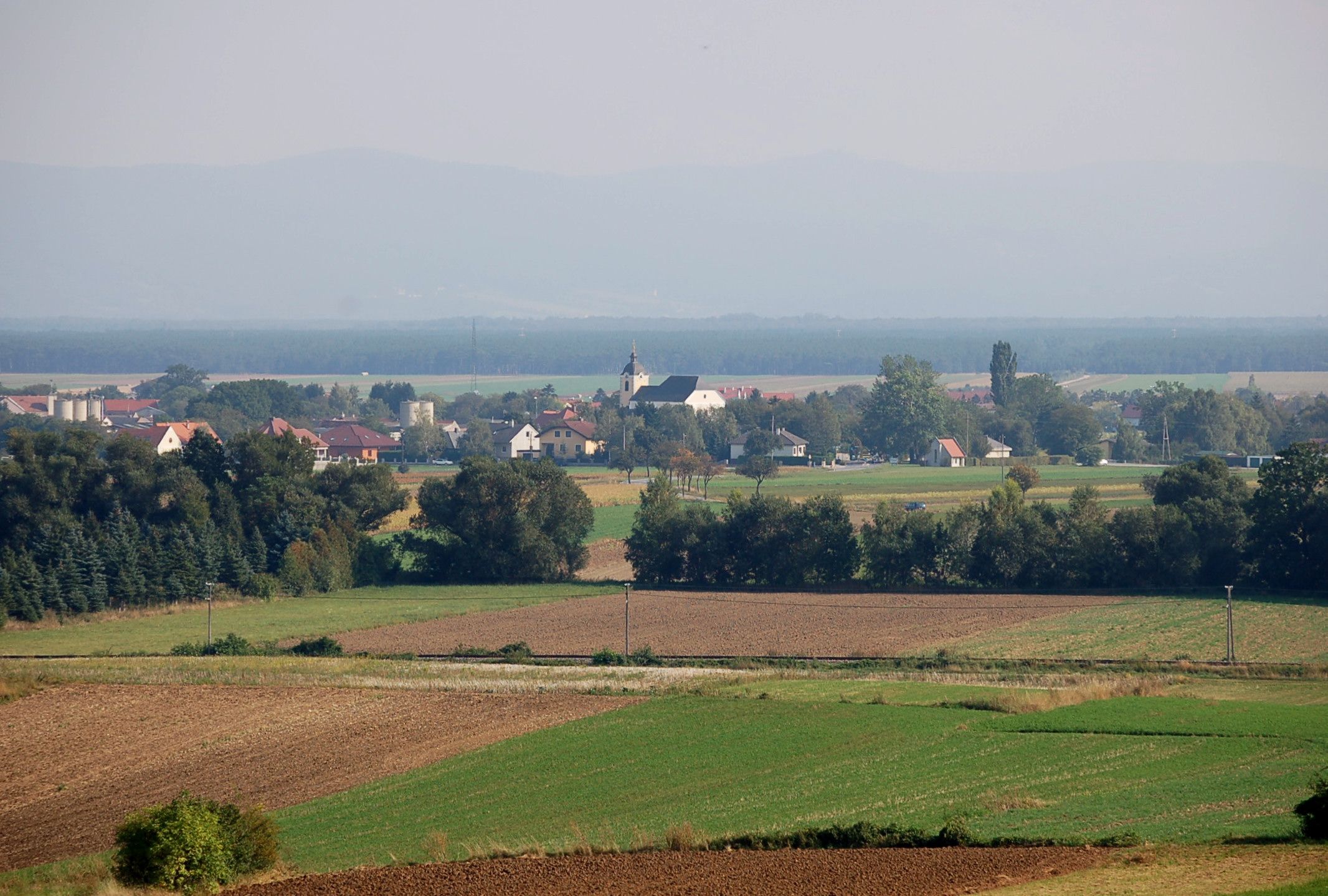 Krajina s poli a vesnicí v pozadí, Weikersdorf am Steinfelde.