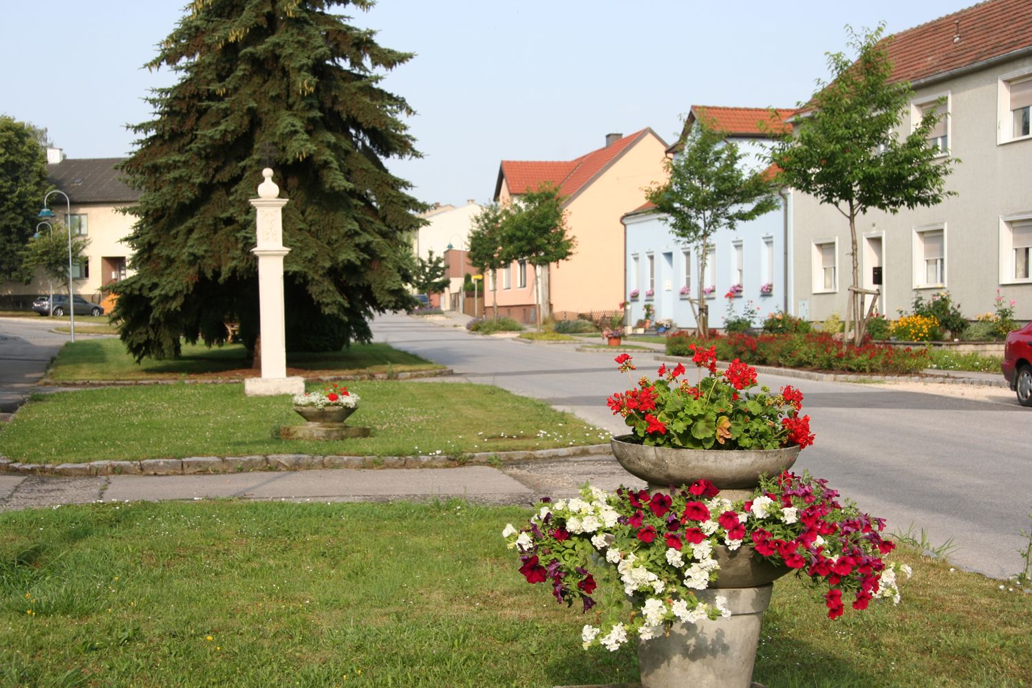 Ulice v Sierndorfu s barevnými květinami a domy.