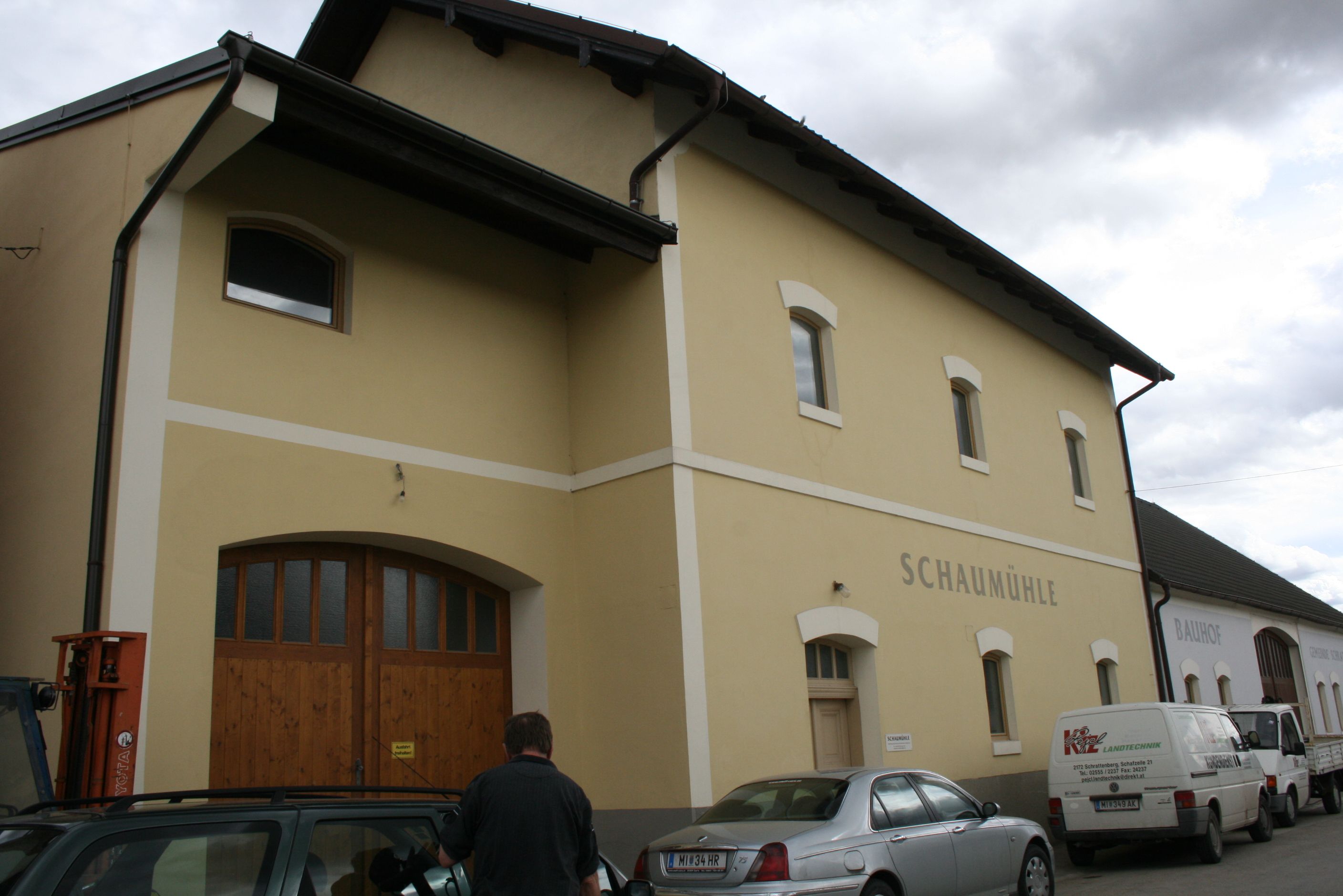 Vnější pohled na žlutou budovu s označením "Schaumühle".