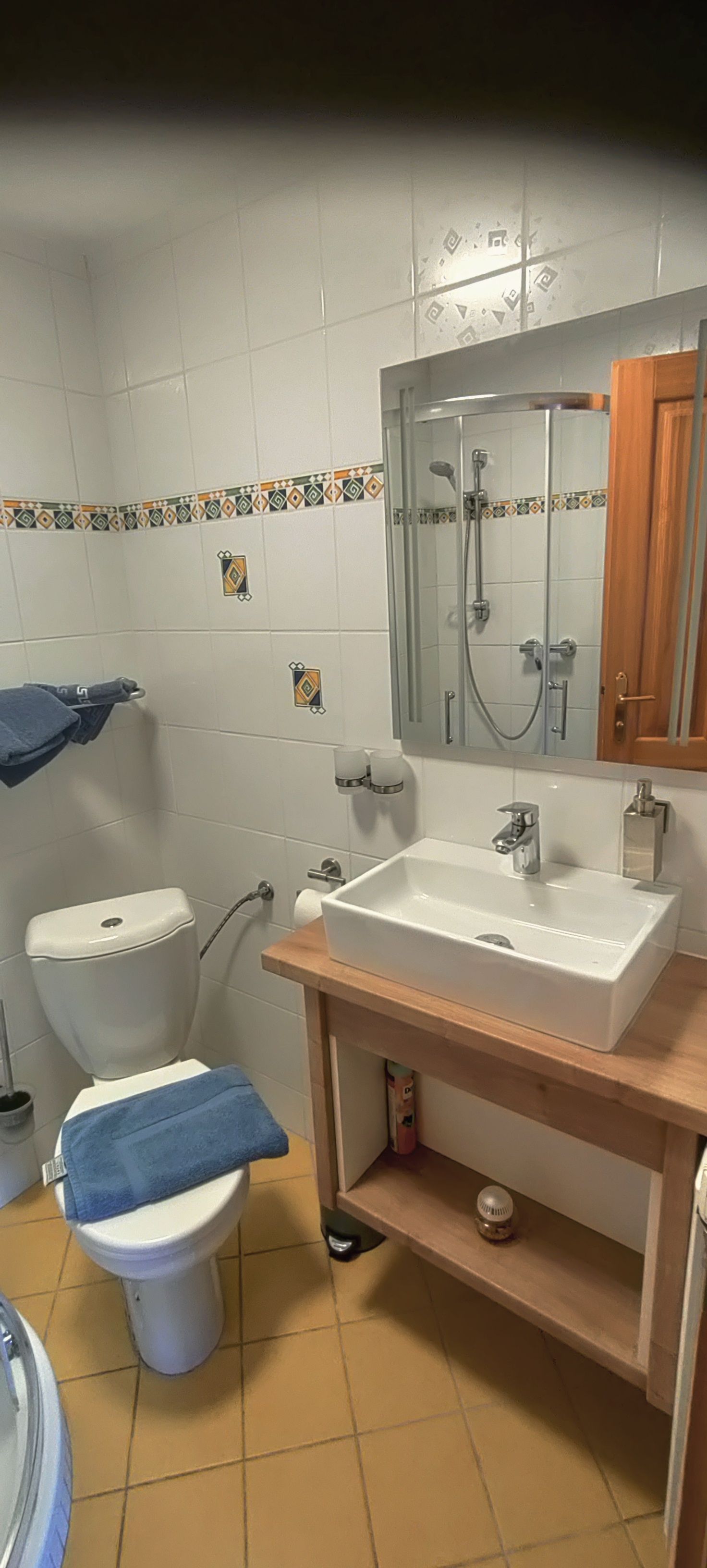 Malá koupelna s toaletou, umyvadlem a zrcadlem.