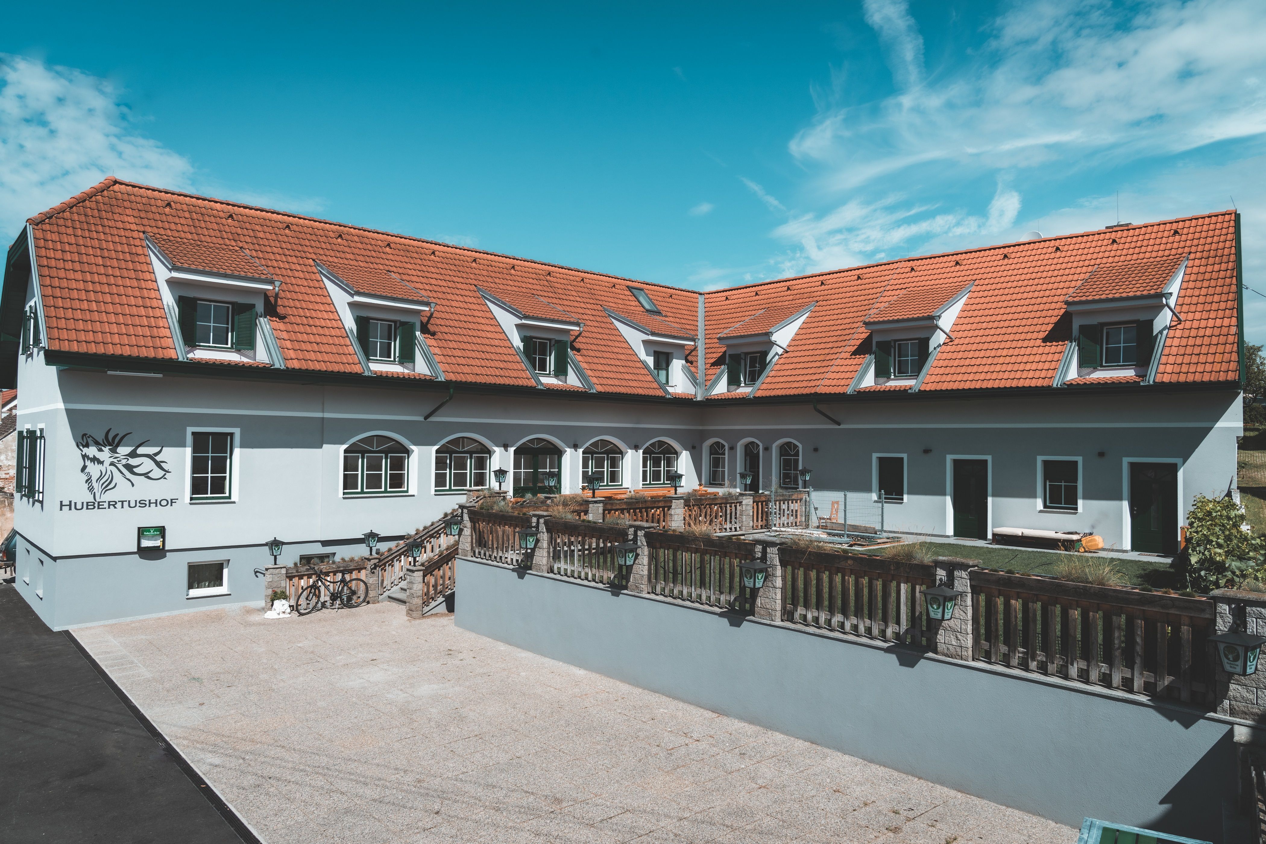 Budova s červenými střešními taškami a několika střešními okny, označená jako "Hubertushof".