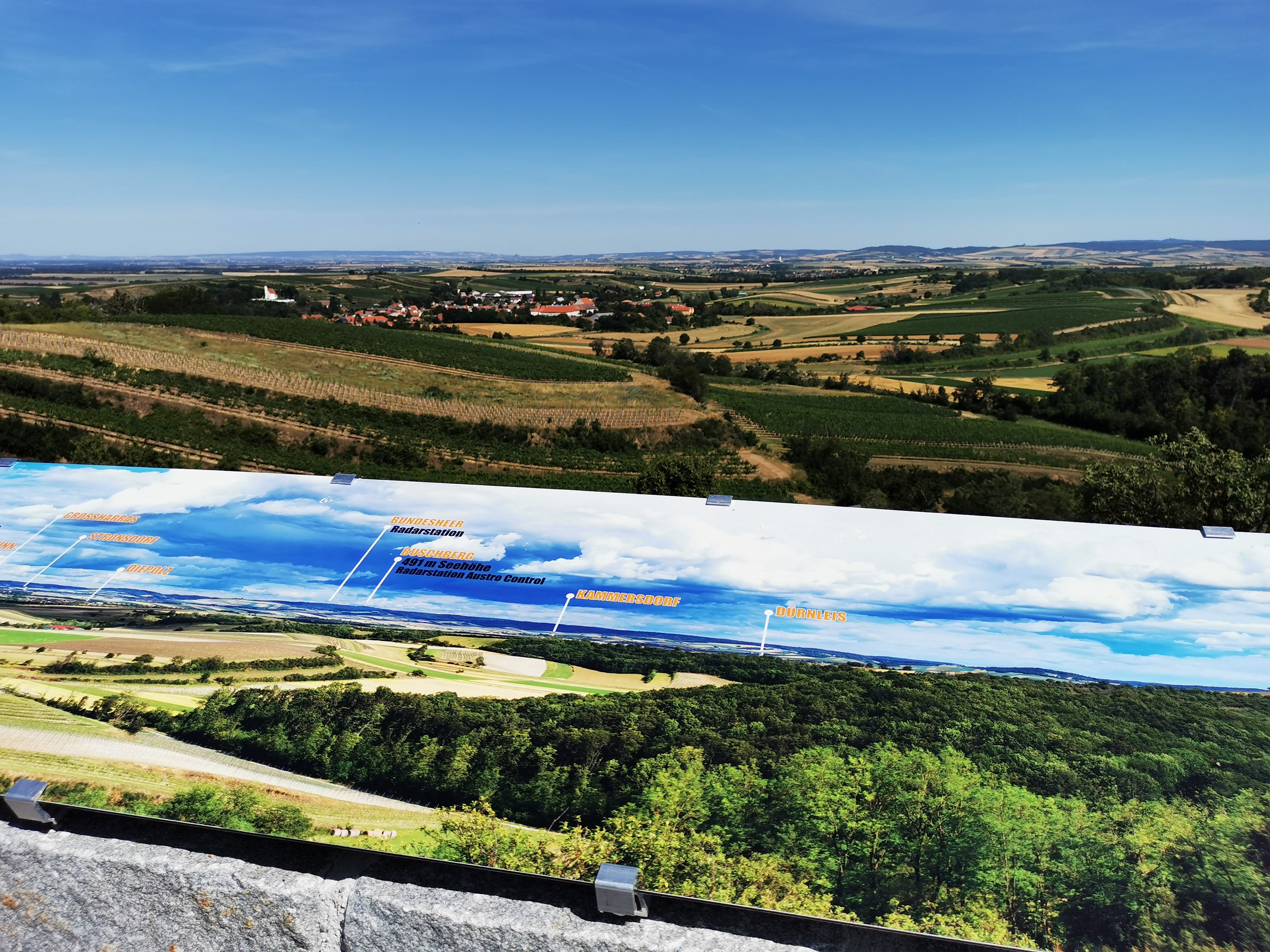 Panoramatický pohled z vyhlídky Vösenau s krajinou a informační tabulí.