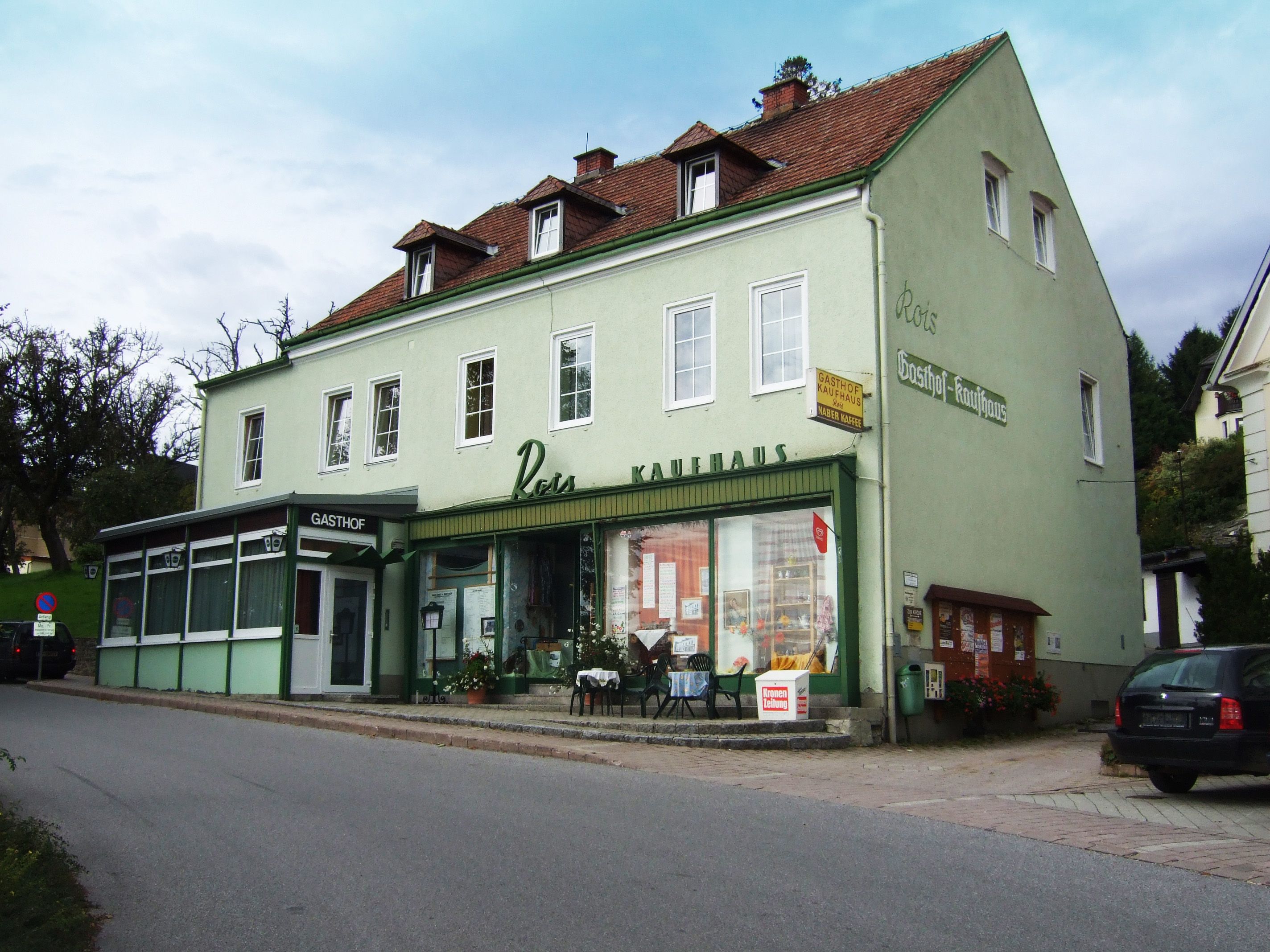 Zelená budova s označením "Gasthof Rois".