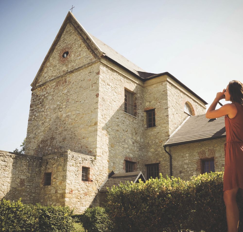Eine Frau fotografiert das Kloster St. Anna in der Mannersdorfer Wüste. 