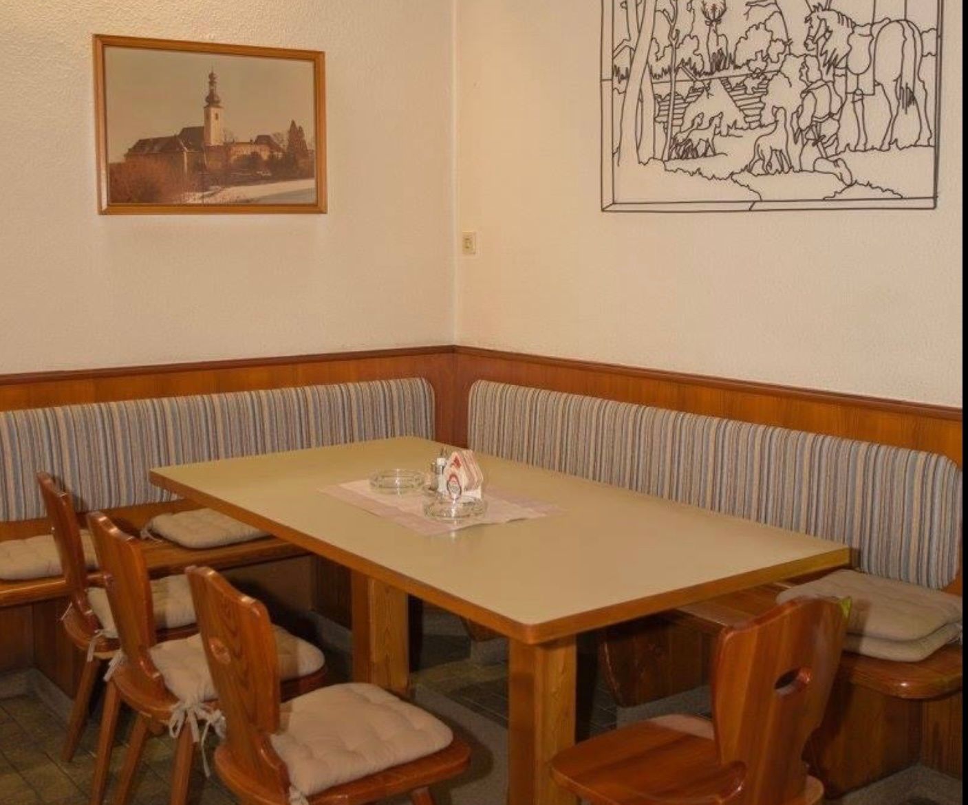 Útulné posezení v hostinci s dřevěným nábytkem a nástěnnými dekoracemi.