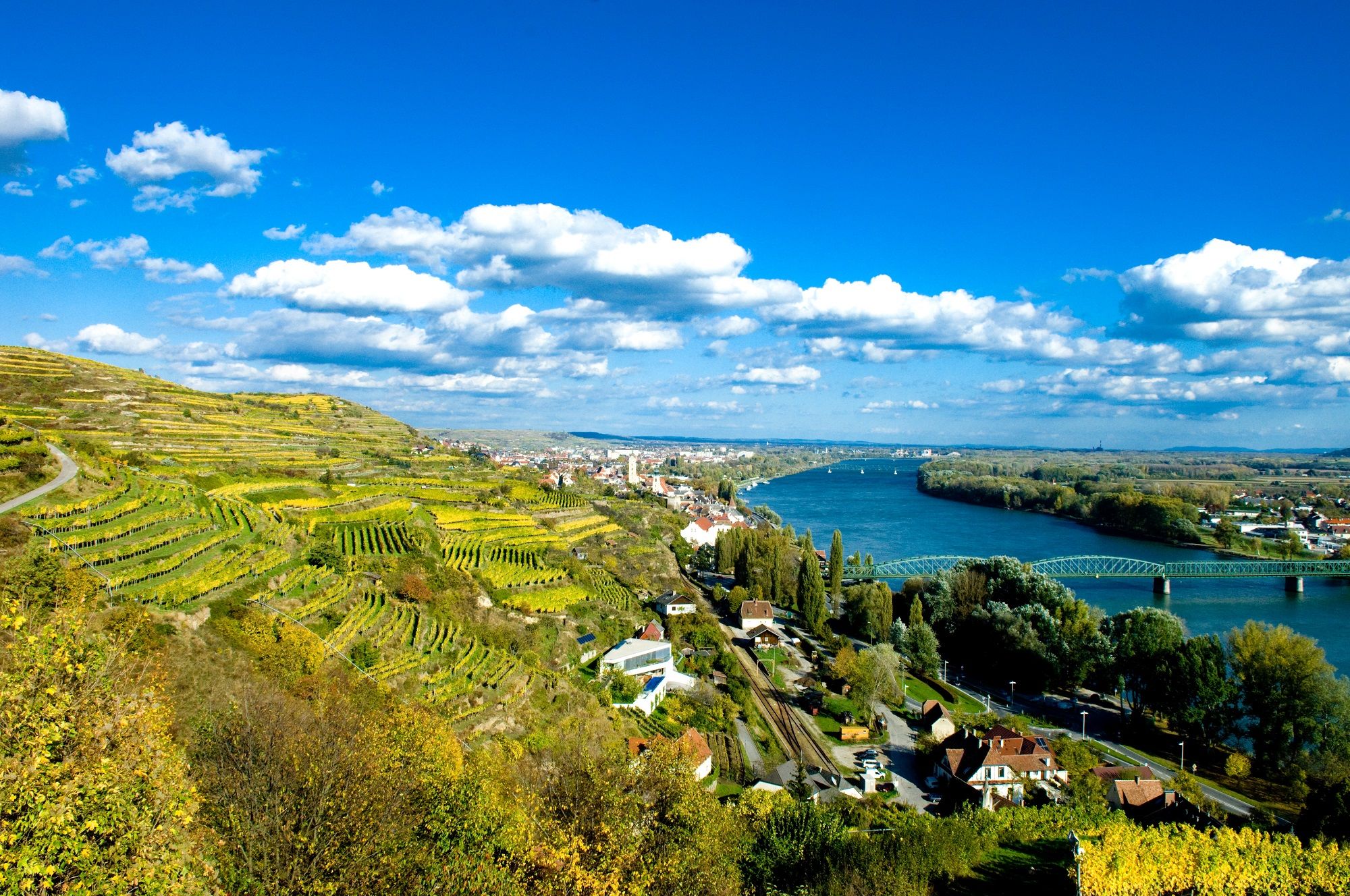 Krajina s vinicemi, řekou a mostem v rakouském Kremsu.