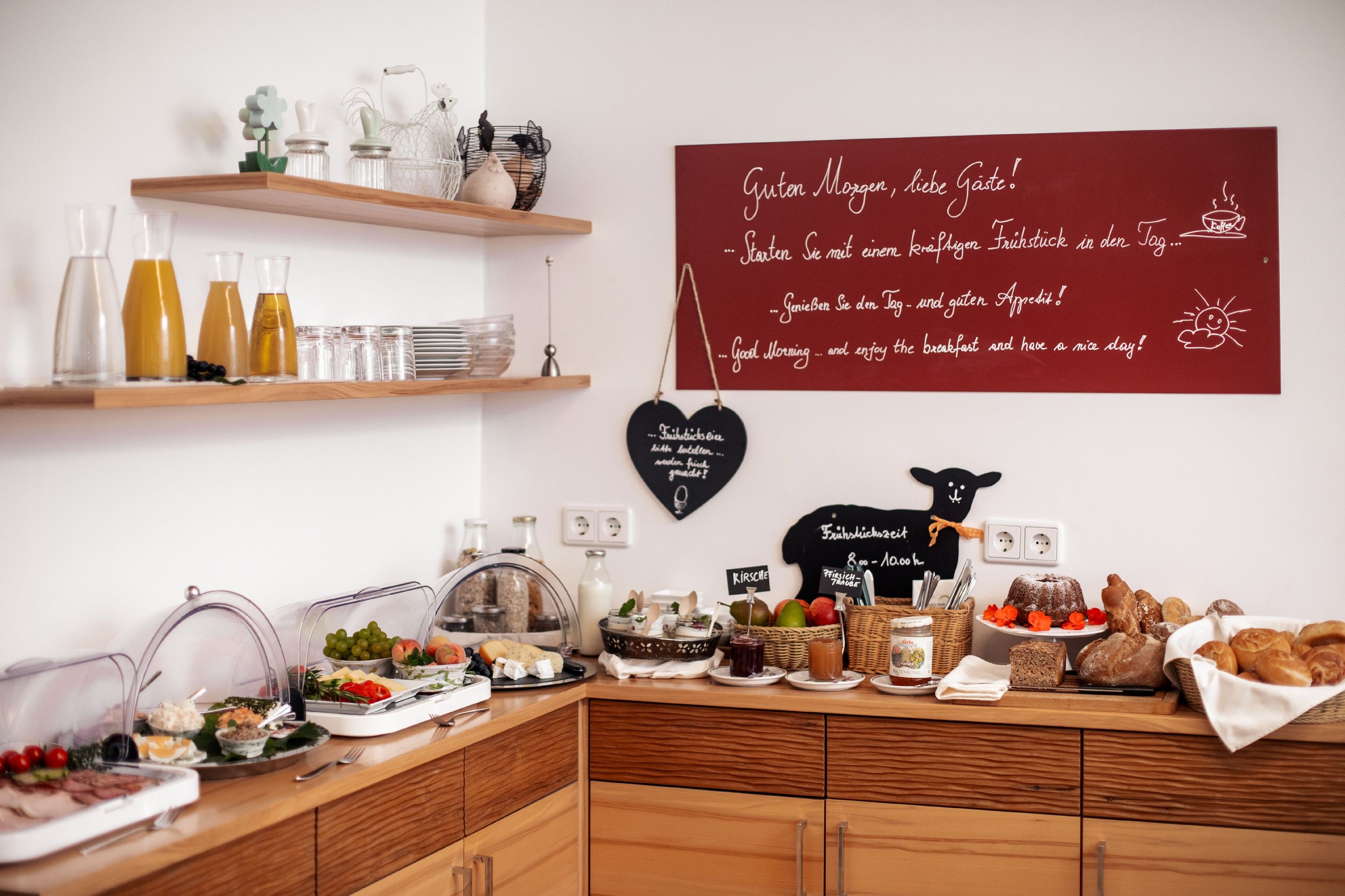 Snídaně formou bufetu s džusem, chlebem, uzeninami a ovocem v útulné místnosti.