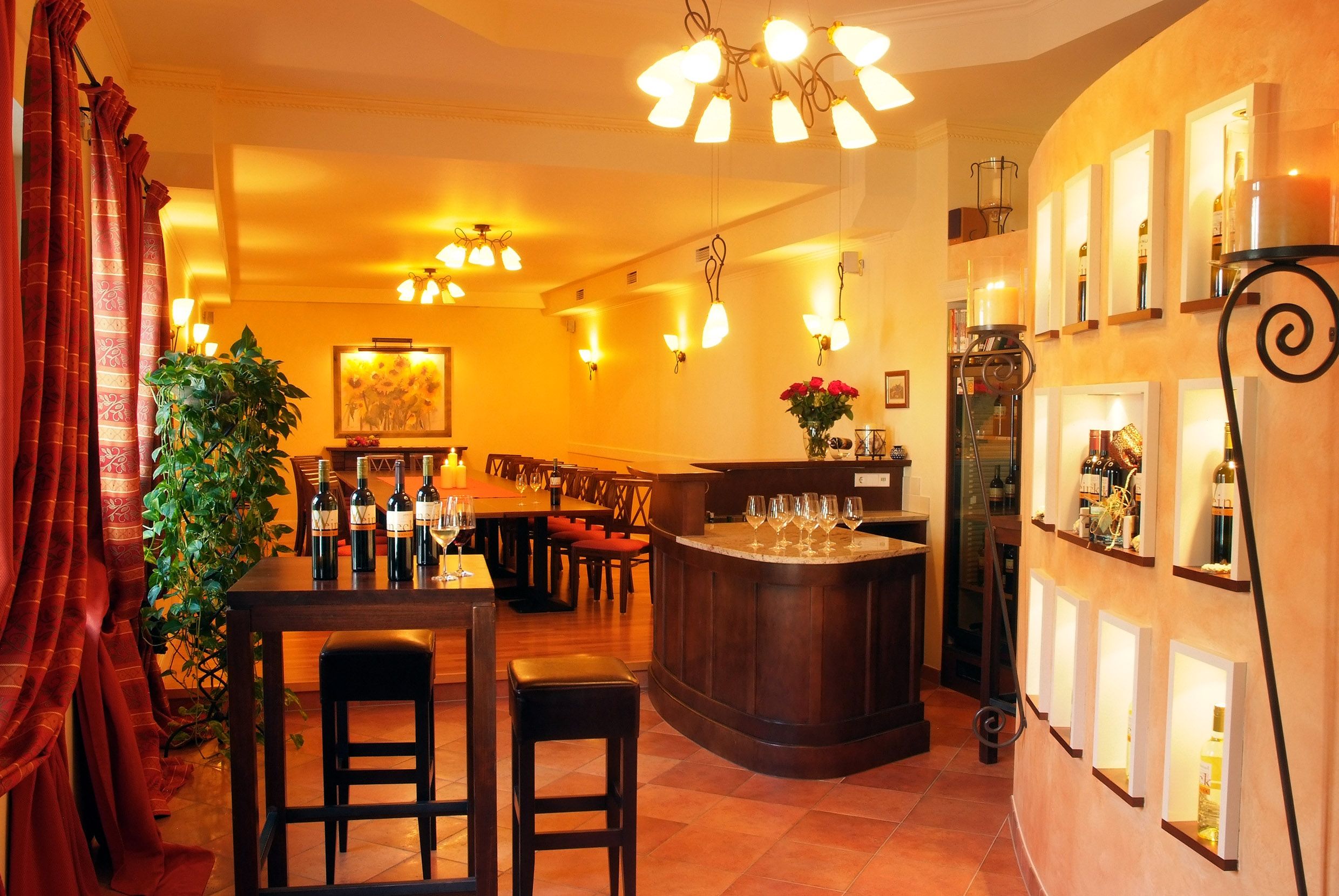 Elegantní degustační místnost s lahvemi vína, sklenicemi a stylovým osvětlením.