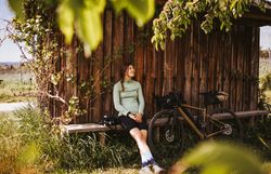 Inmitten der sanften Hügel des Waldviertels genießt eine Radfahrerin eine wohlverdiente Pause. Umgeben von üppigem Grün und der warmen Sonne strahlt die Szene Ruhe und Freiheit aus. Die frische Luft und die malerische Landschaft laden dazu ein, die Schönheit der Natur zu erkunden.