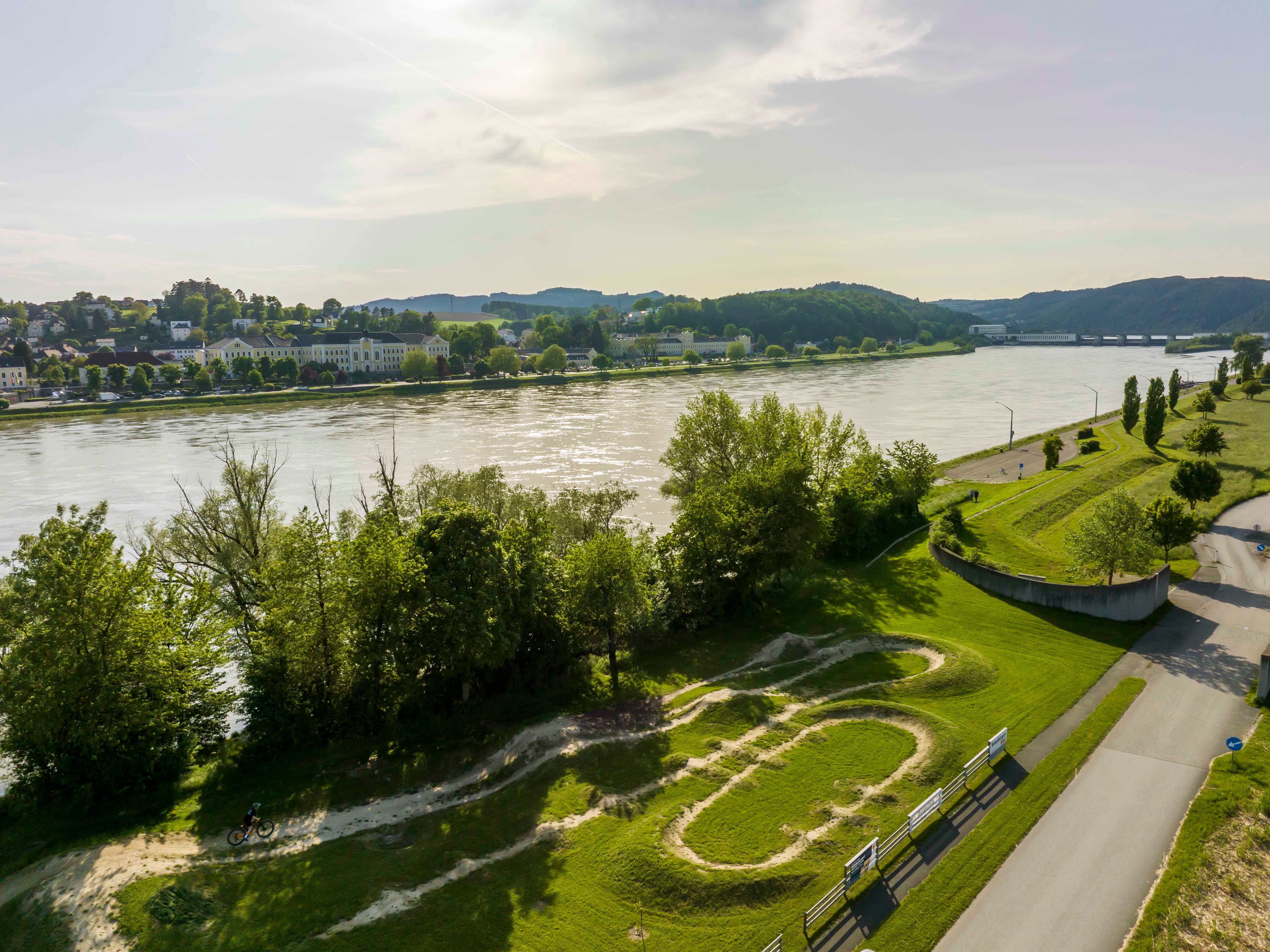 Letecký pohled na cyklistickou arénu Persenbeug-Gottsdorf s řekou a okolní krajinou.