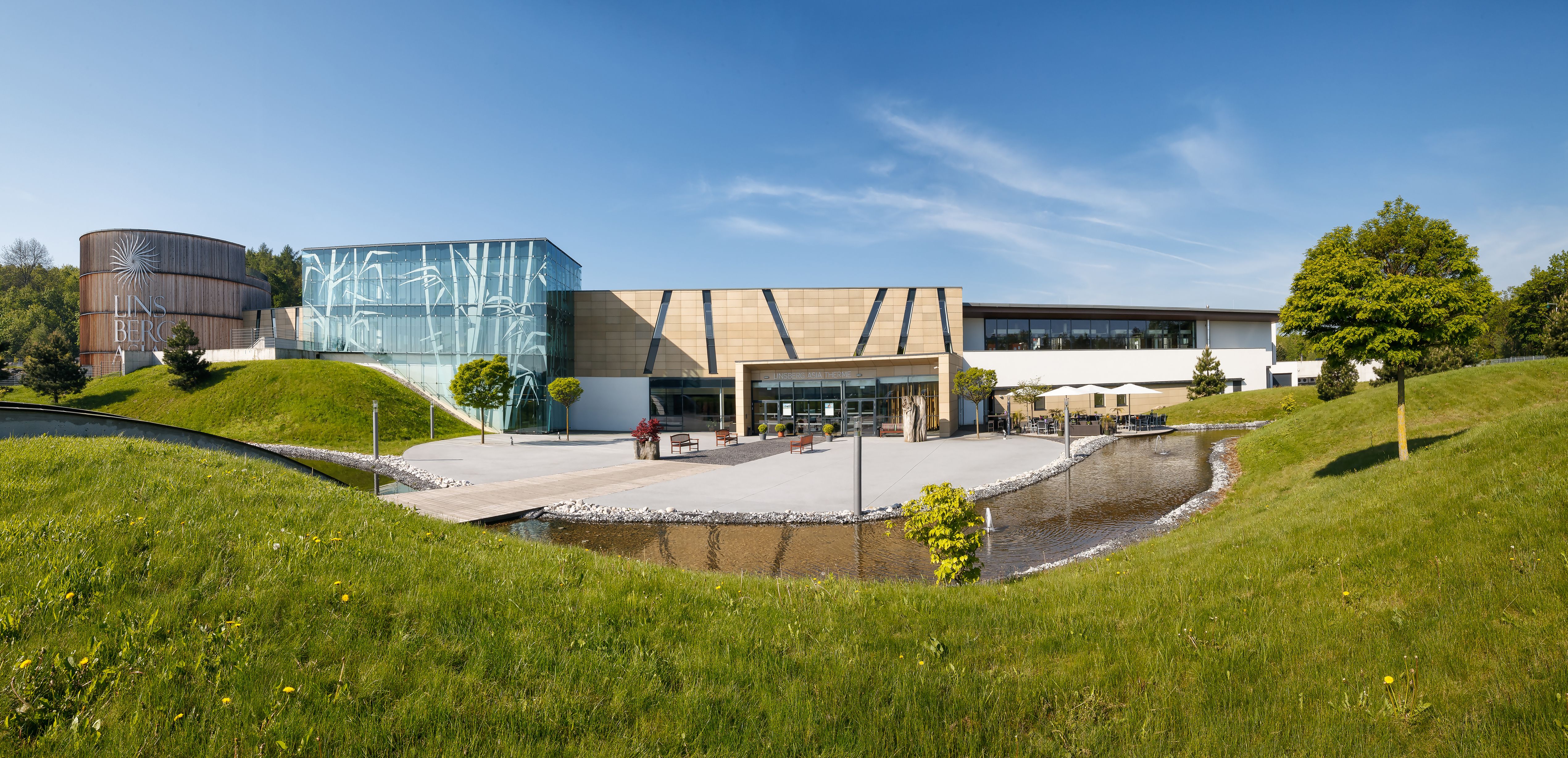 Vnější pohled na lázně Linsberg Asia Therme s moderní architekturou a zelení.