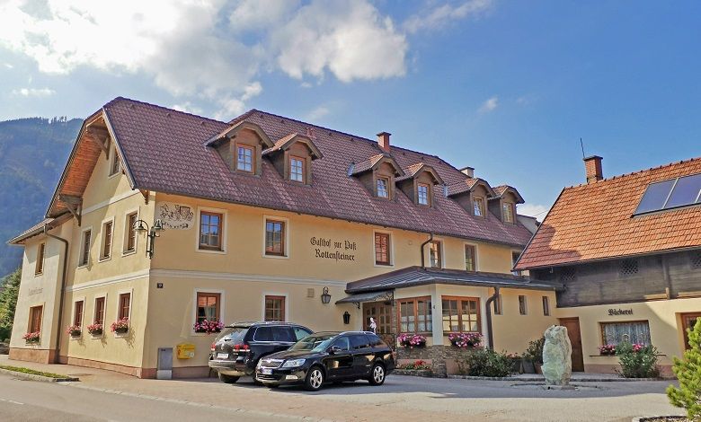 Tradiční hostinec s pekárnou a zaparkovanými auty před ním.