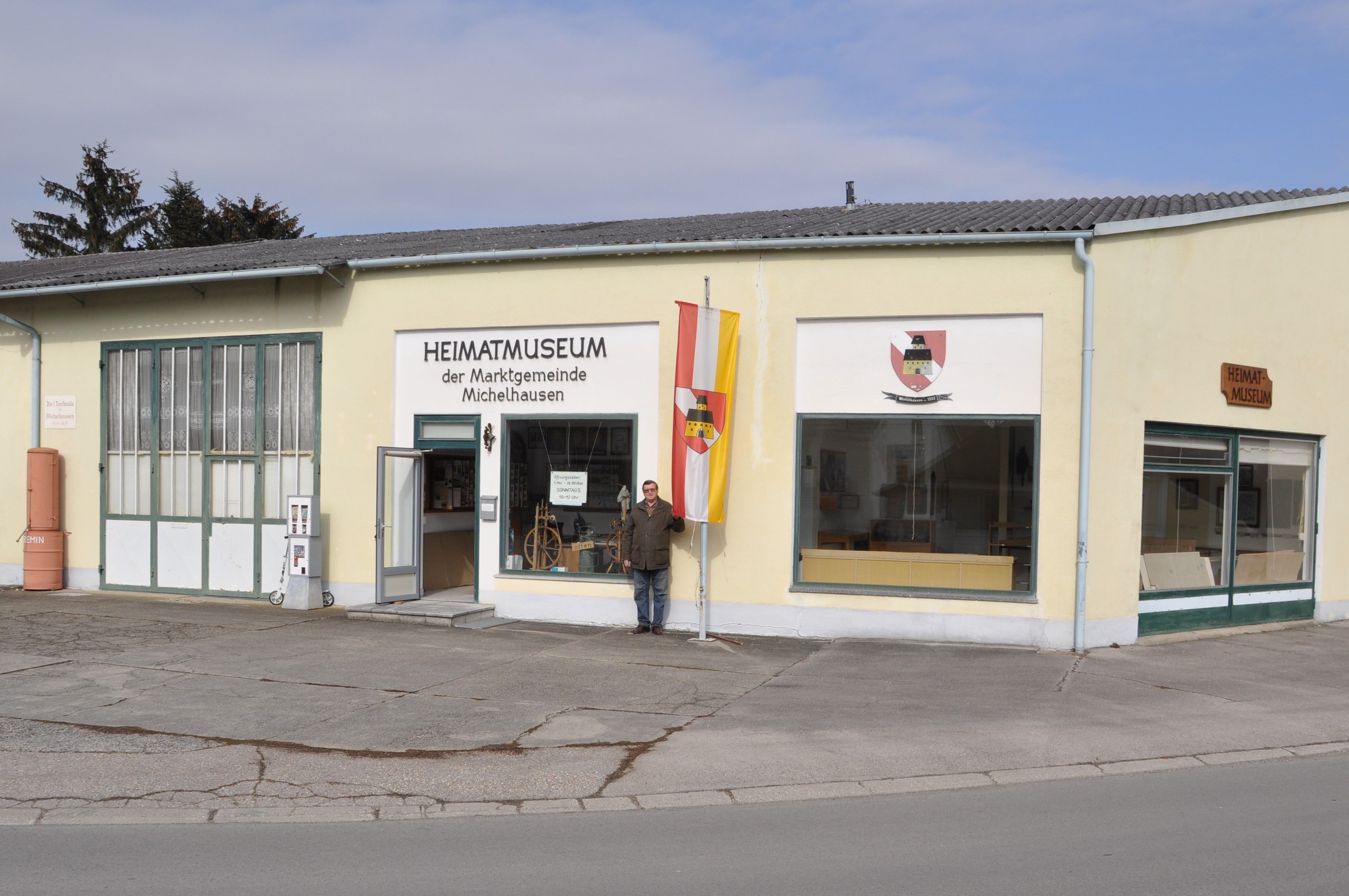 Pohled na místní historické muzeum v Michelhausenu se žlutou budovou a vlajkou.