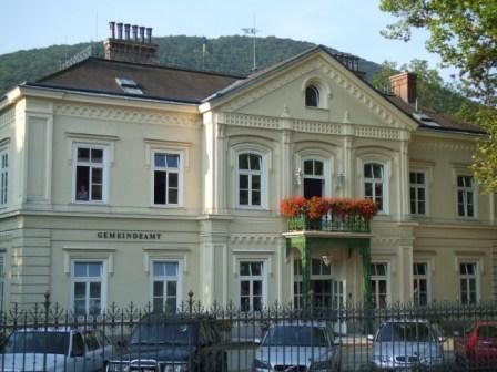 Historická budova s balkonem a květinami v Hinterbrühlu.