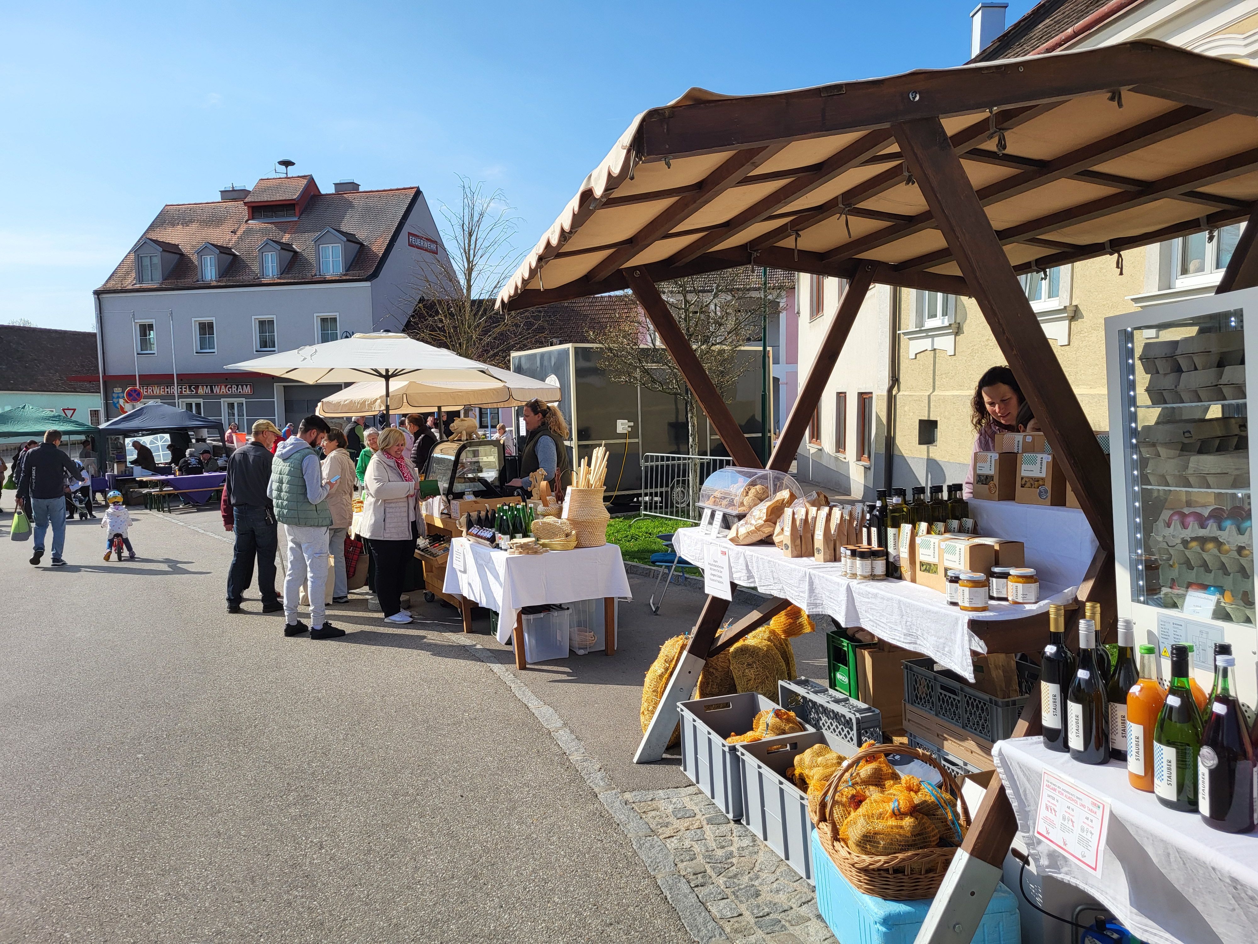 Trh na hlavním náměstí ve Felsu s regionálními produkty v popředí.
