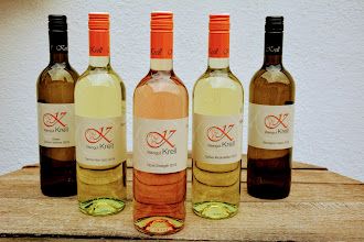 Pět lahví vína z vinařství Krell na dřevěném stole.