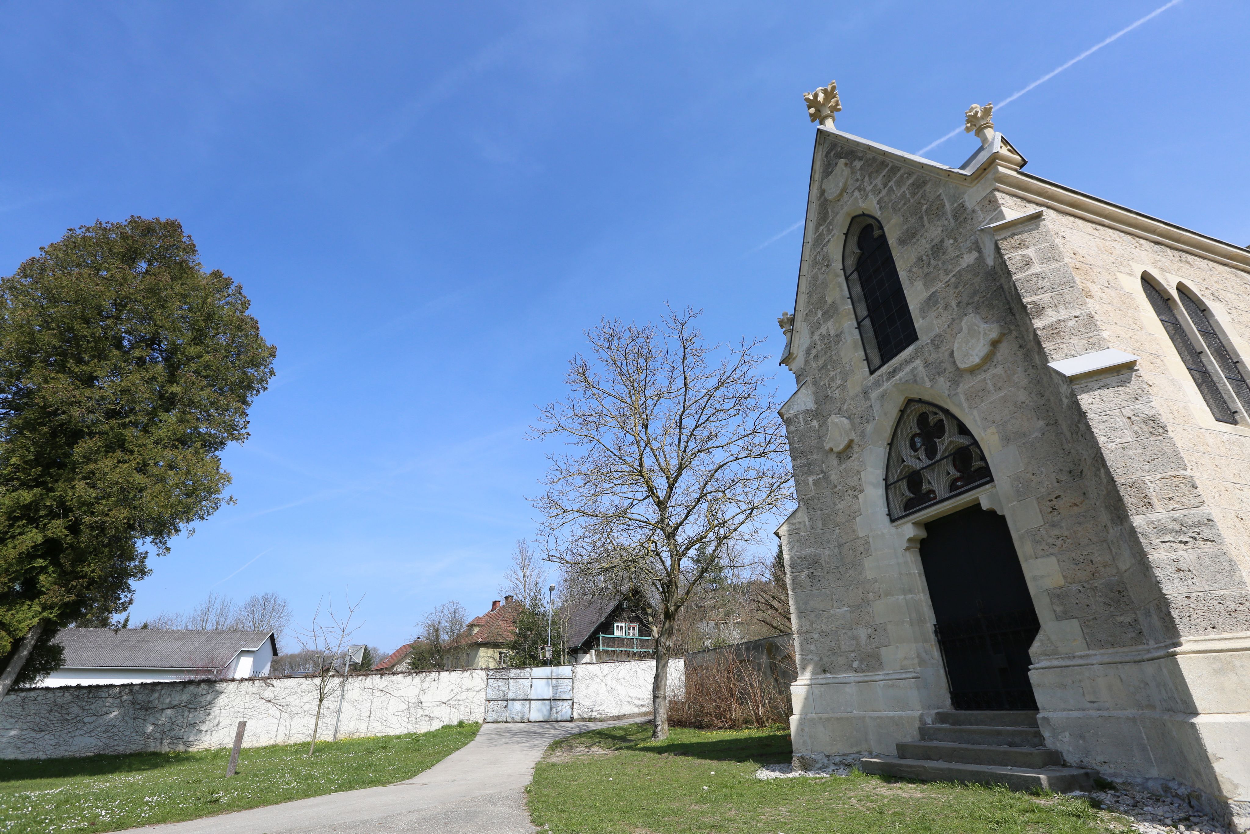 Töppermausoleum s modrou oblohou a stromy v pozadí.