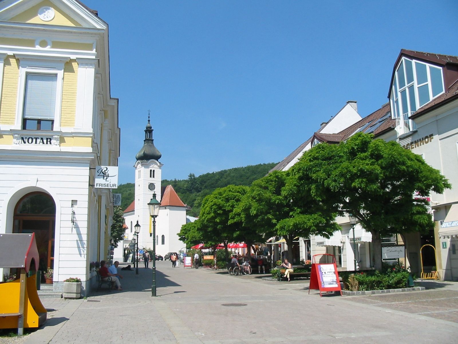 Hlavní náměstí v Purkersdorfu s kostelem a obchody.