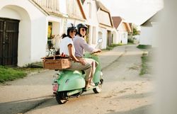Ein fröhliches Paar genießt die sanfte Brise des Herbstes auf ihrem Roller, während sie durch die malerischen Gassen der Kellergasse Maulavern fahren. Umgeben von idyllischen Weinhängen und charmanten Weinkellern, strahlt die Szene eine entspannte Urlaubsatmosphäre aus, die zum Entdecken einlädt.