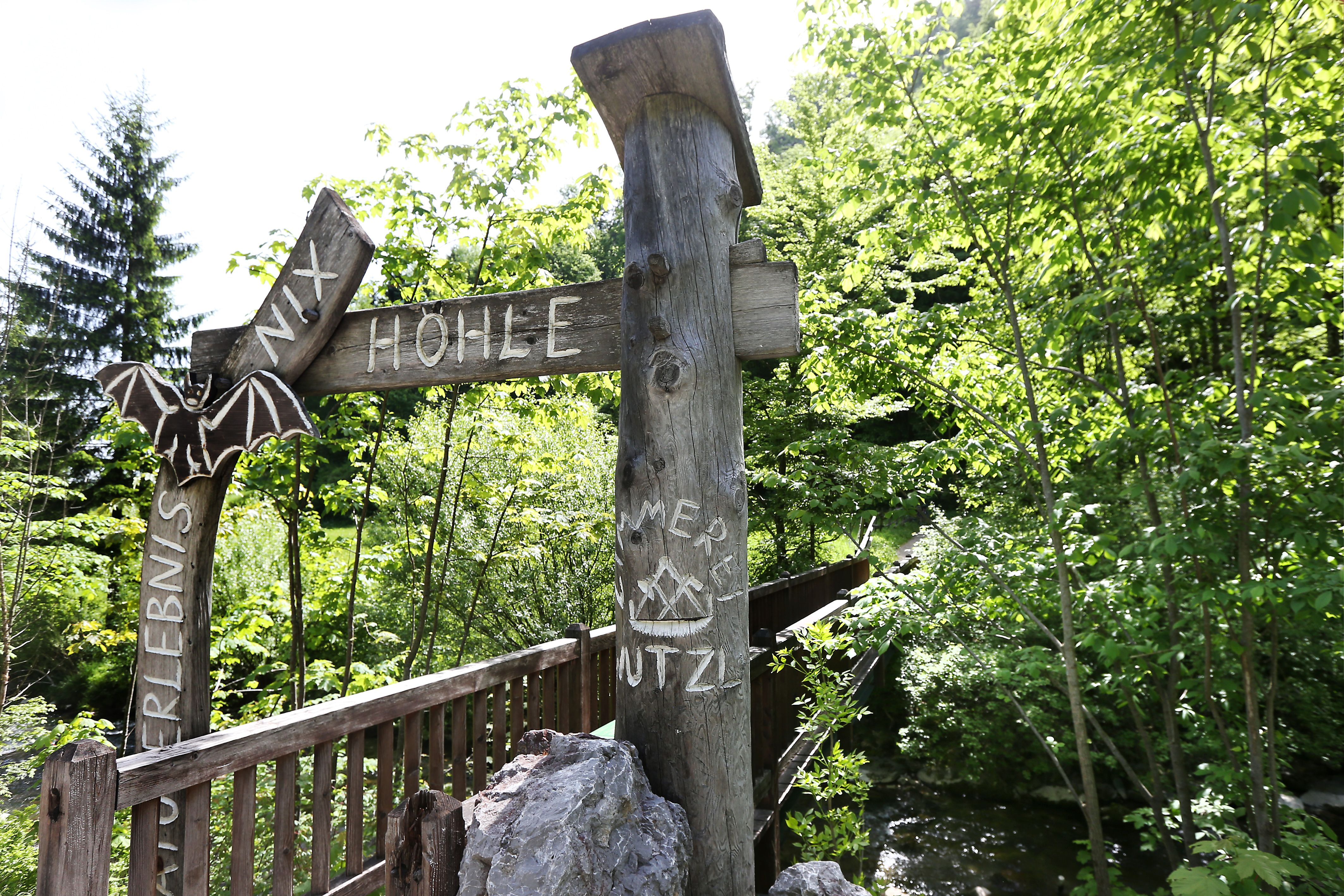 Vchod do jeskyně Nix u Frankenfelsu s dřevěnou cedulí a netopýří výzdobou.