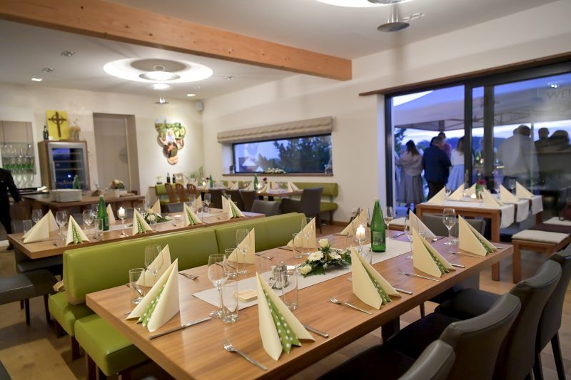 Elegantní degustační místnost s prostřenými stoly a výzdobou.