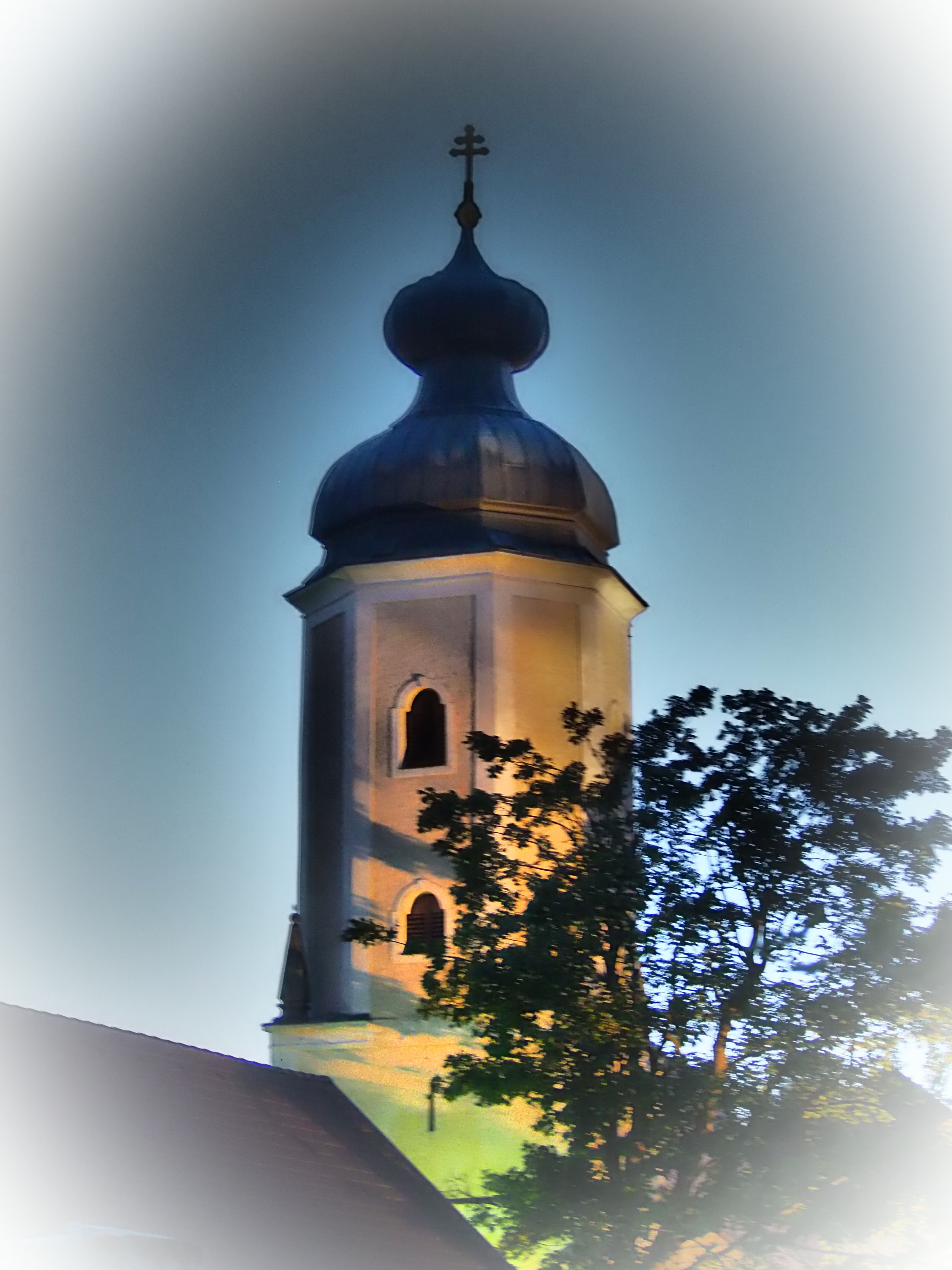 Osvětlená věž farního kostela v Sallingbergu za soumraku.