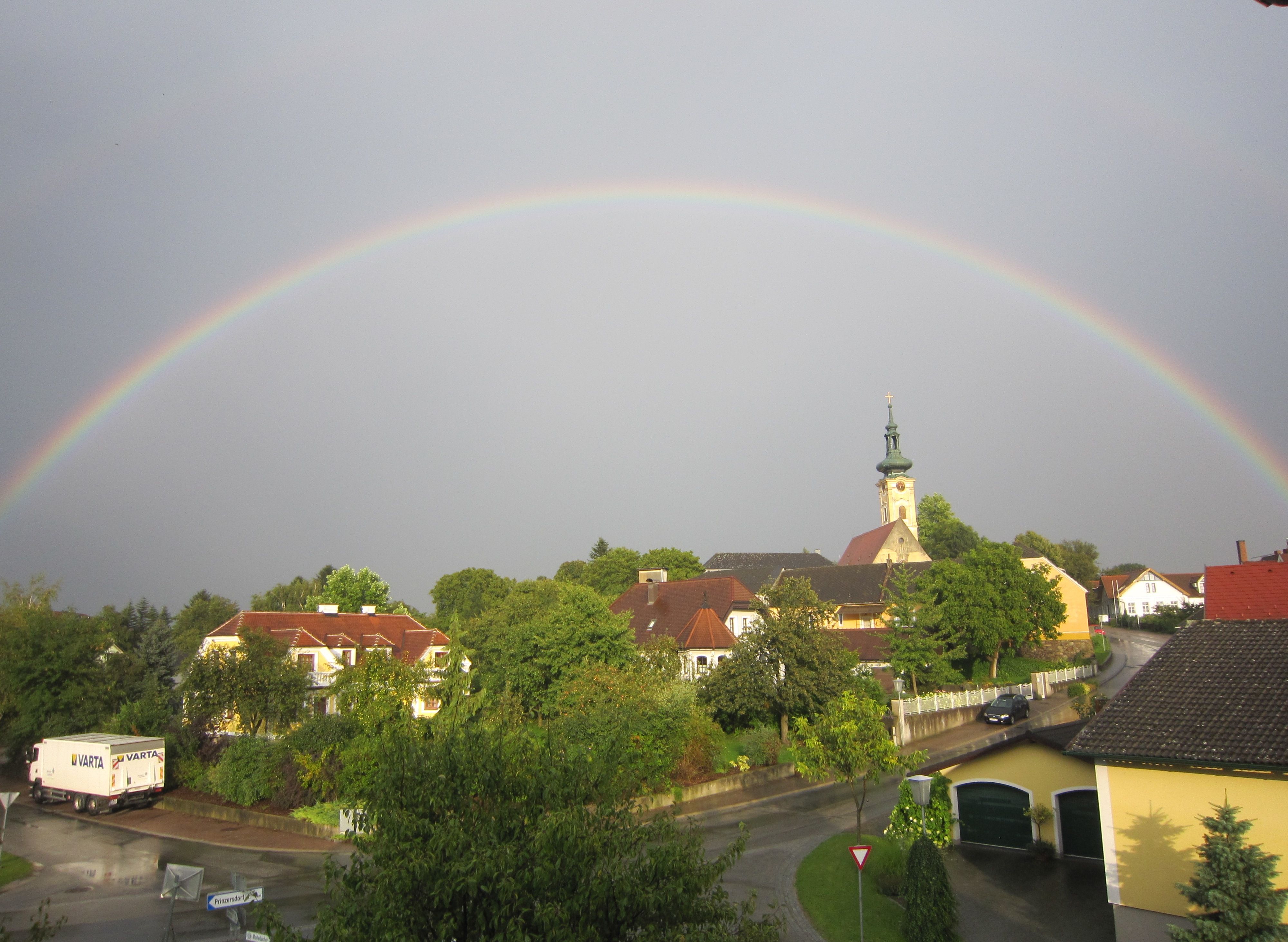 Duha se táhne nad vesnicí s kostelem a domy v Gerersdorfu.