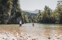 Paar watet im Fluss entlang des Ybbstalradwegs