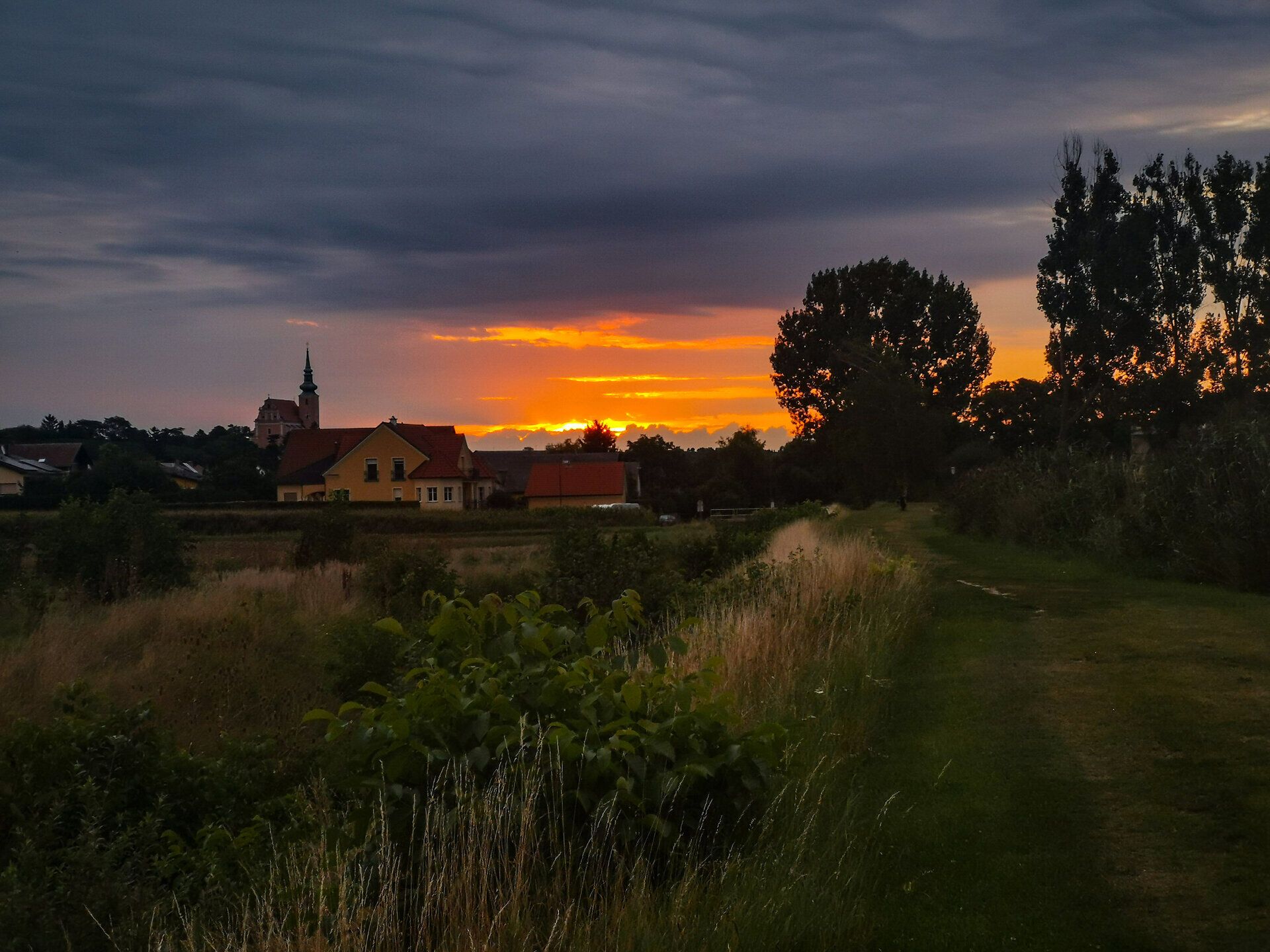 Ein malerischer Sonnenuntergang taucht die sanften Hügel des Weinviertels in warmes Licht, während die letzten Strahlen des Tages die Landschaft verzaubern. Die ruhige Atmosphäre lädt dazu ein, die Schönheit der Natur zu genießen und den Alltag hinter sich zu lassen.