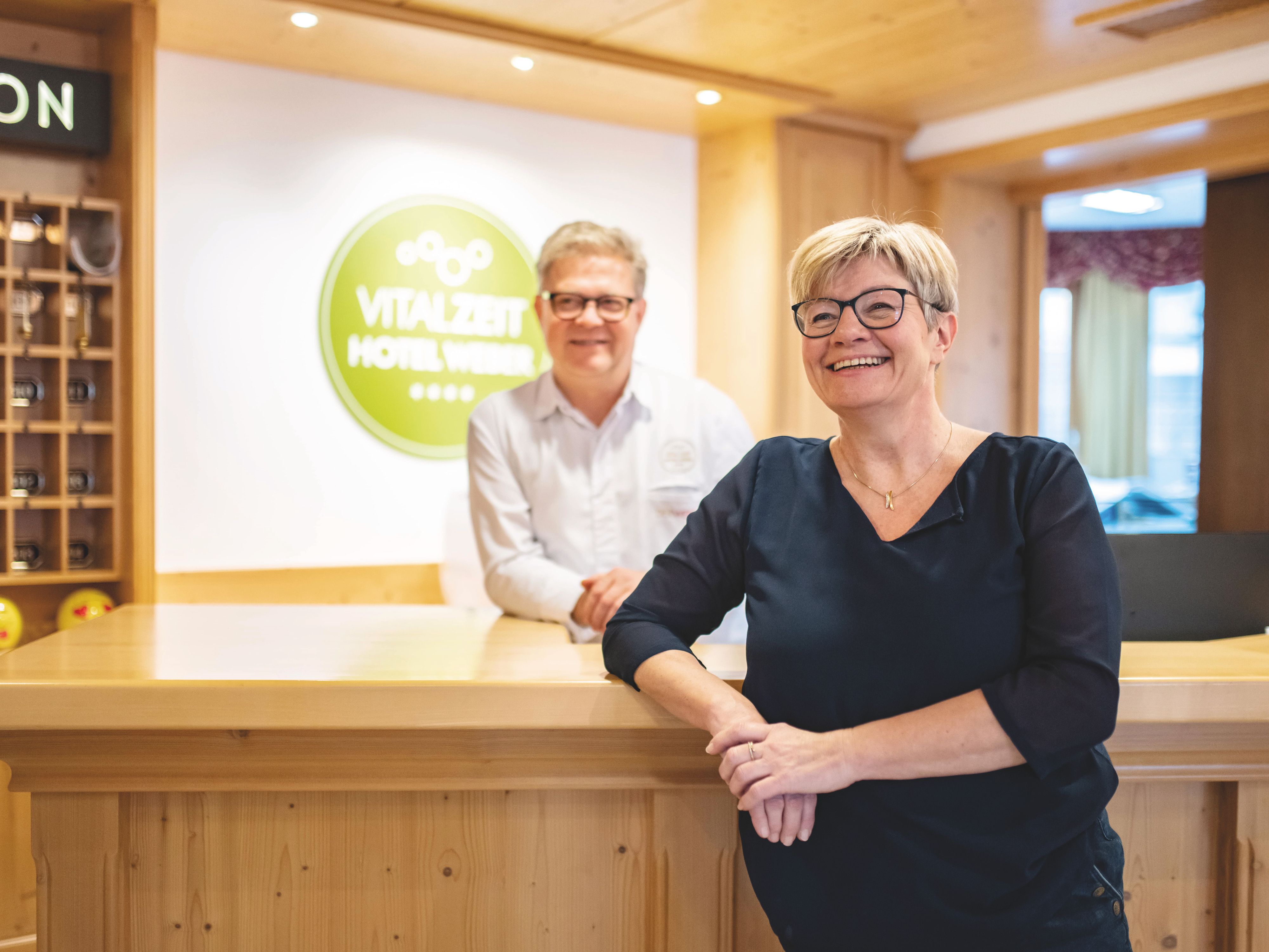 Petra a Alfred Weber stojí s úsměvem u recepce hotelu VitalZeit Hotel Weber.