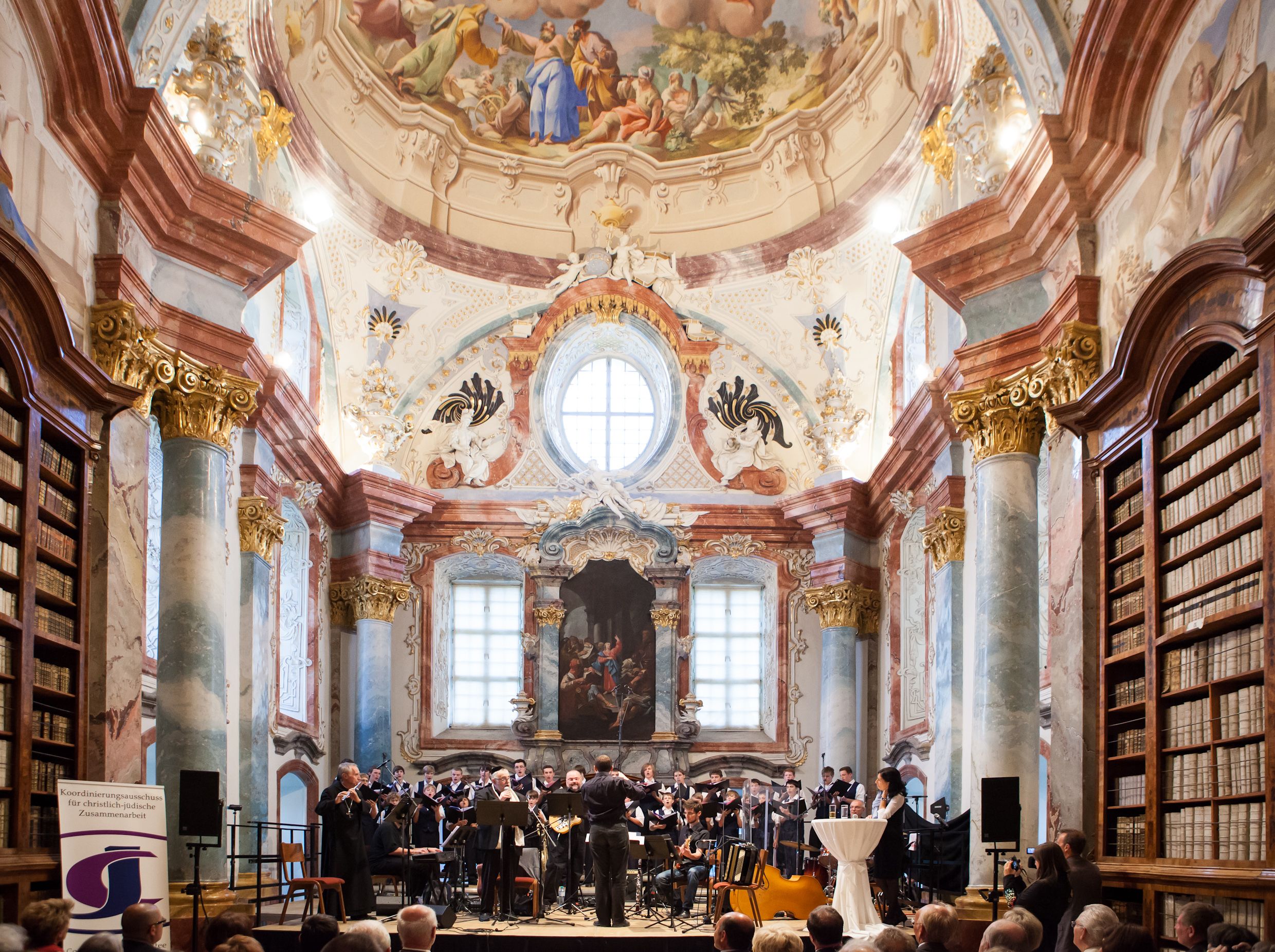Koncert v barokní knihovně opatství Altenburg s orchestrem a sborem.