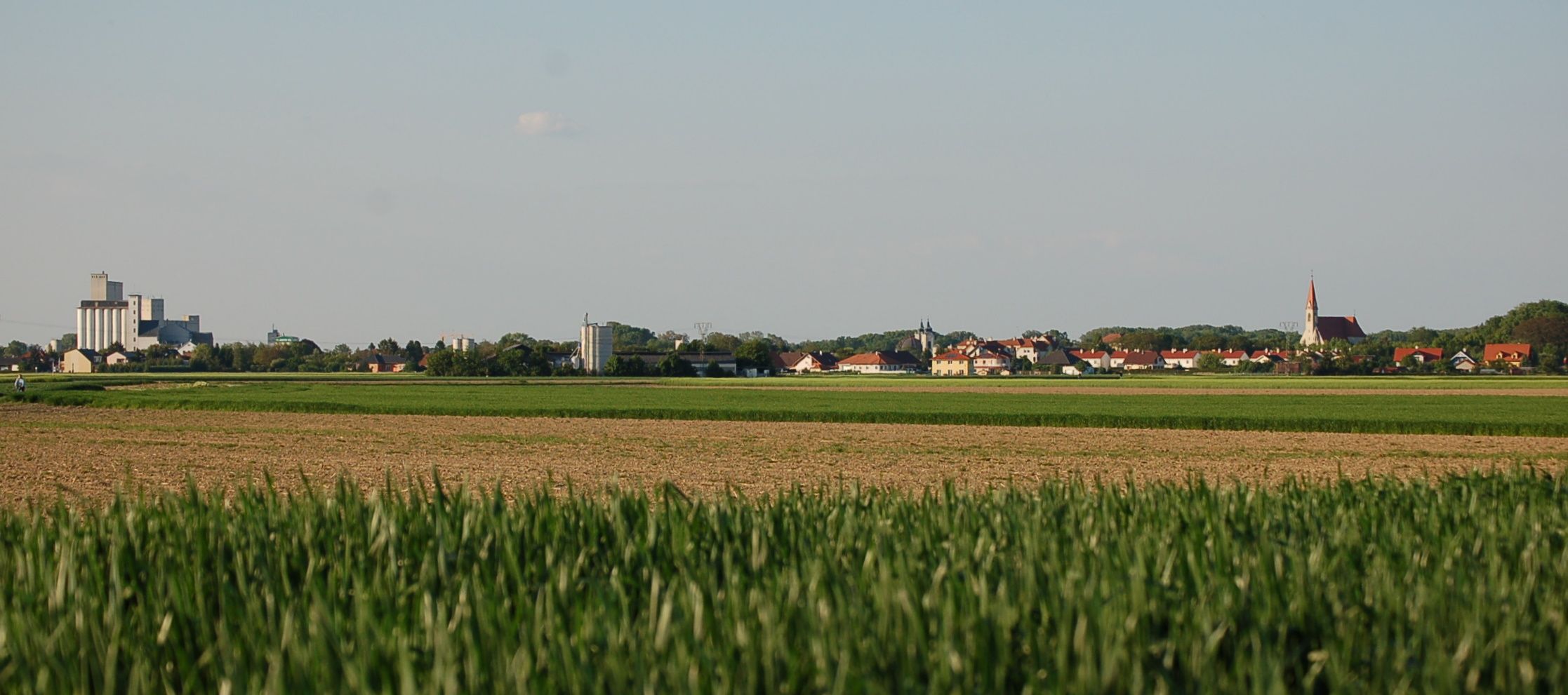 Panorama Lichtenwörthu s poli v popředí a budovami v pozadí.
