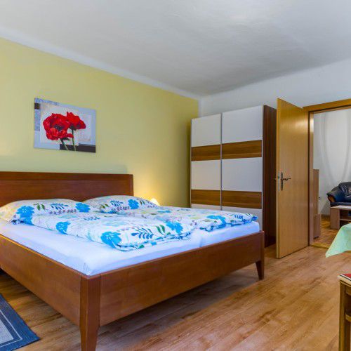 Manželská postel s modrým ložním prádlem