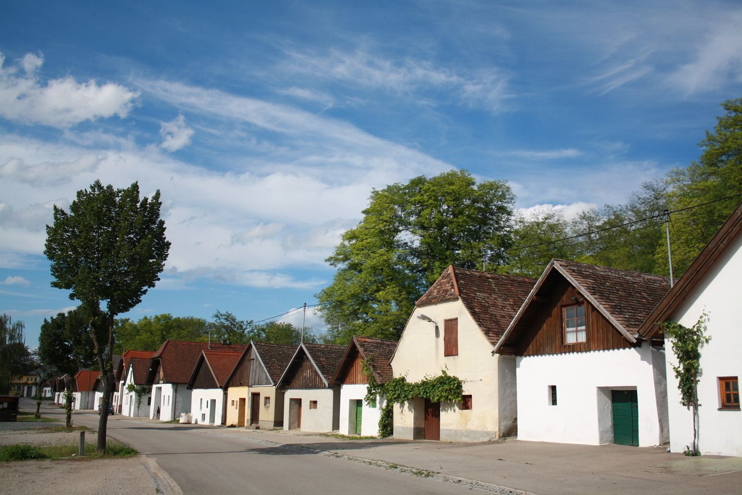 Řada tradičních vinných sklepů ve sklepních uličkách s modrou oblohou.