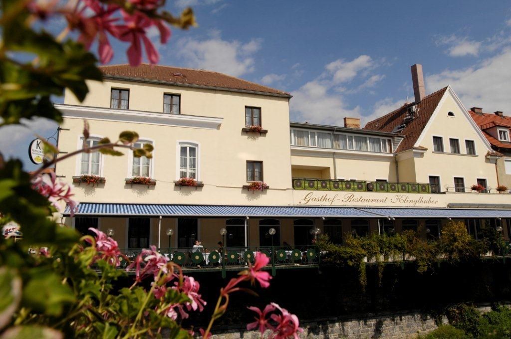 Hotel a hostinec Klinglhuber s květinami v popředí.
