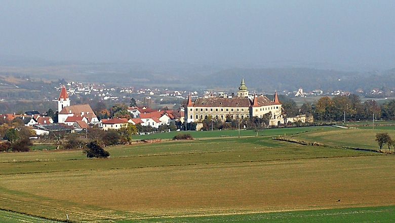 Krajina s kostelem a hradem v dálce.