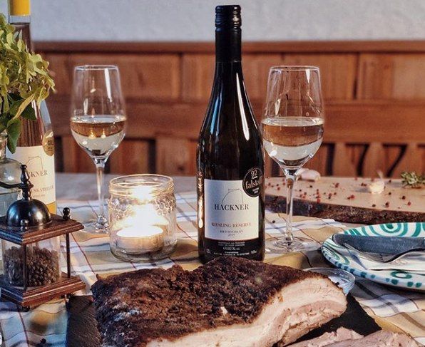 Stůl s lahví vína, dvěma skleničkami, svíčkou a miskou na maso.