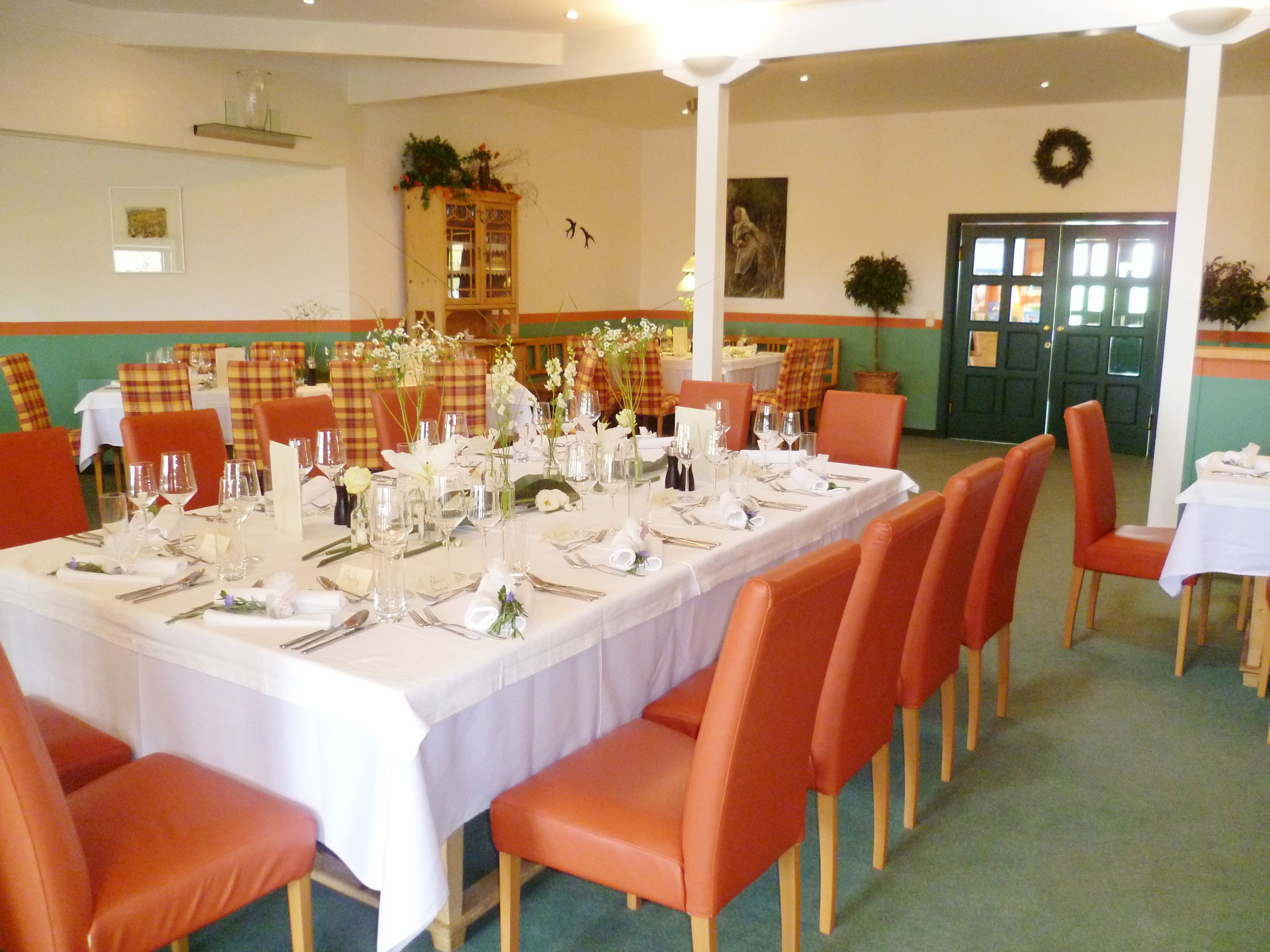 Elegantní restaurace s prostřeným stolem a červenými židlemi.