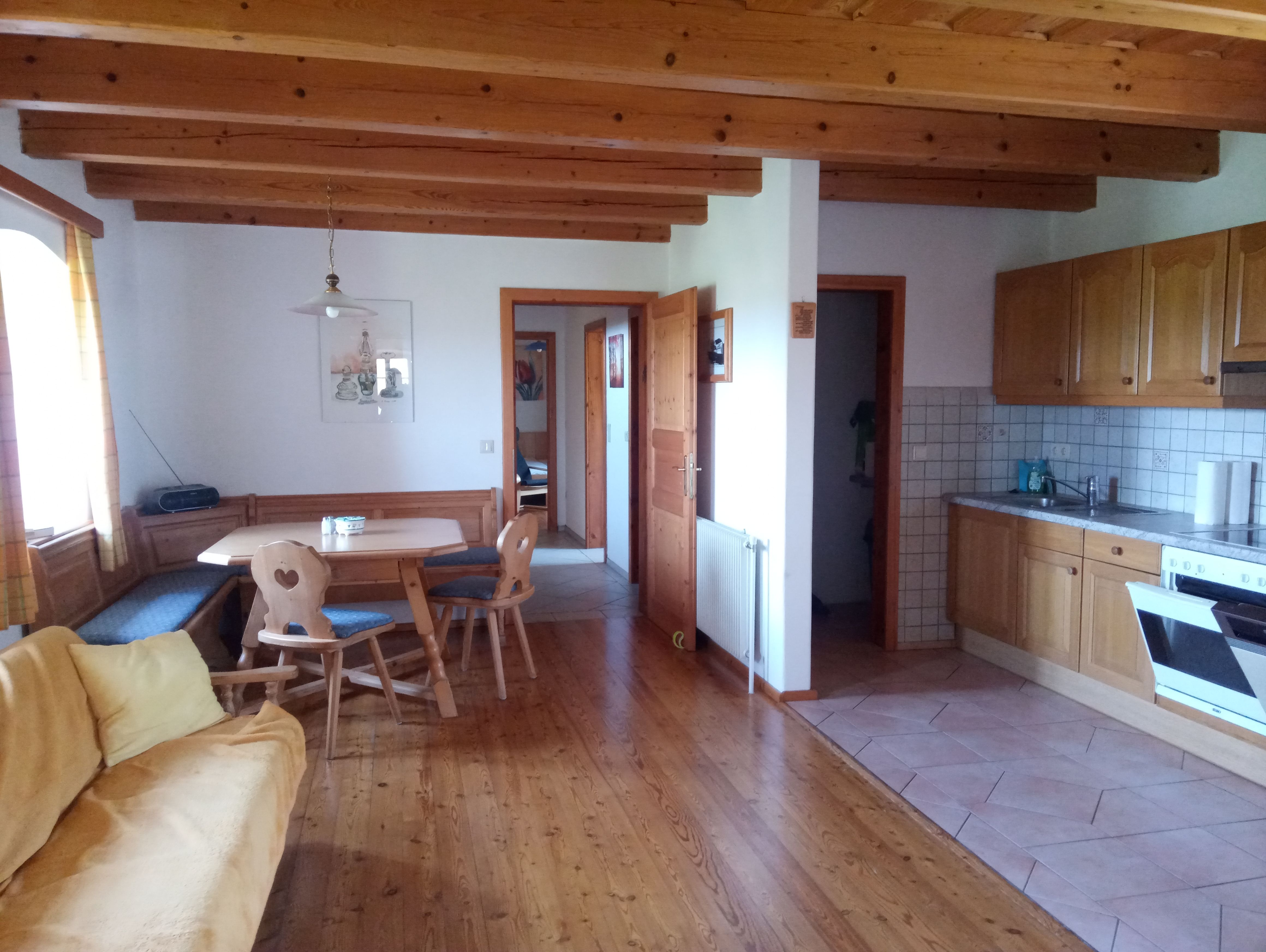 Útulný prázdninový byt s dřevěným nábytkem a kuchyní.