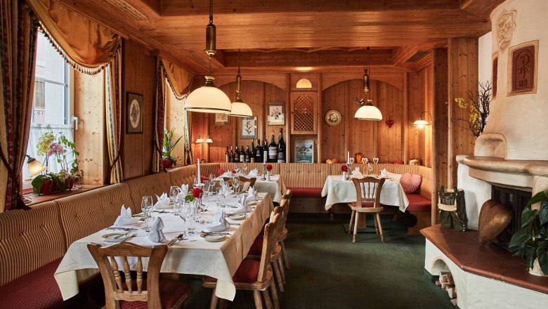 &Uacute;tuln&aacute; restaurace s dřevěn&yacute;mi stěnami, kryt&yacute;mi stoly a krbem.