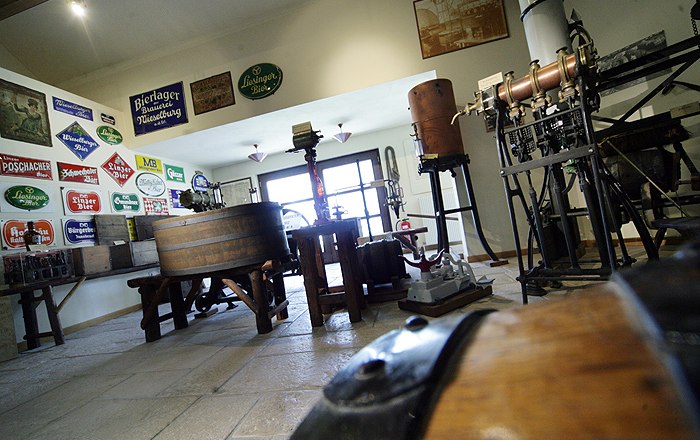 Pohled do interi&eacute;ru muzea pivovaru Wieselburg se star&yacute;m pivovarsk&yacute;m zař&iacute;zen&iacute;m a n&aacute;pisy.