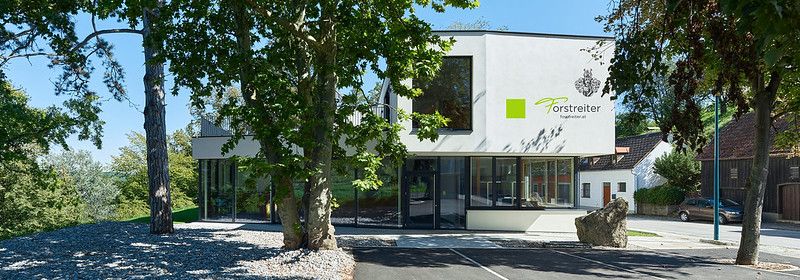 Moderní vinný pavilon v Hollenburgu obklopený stromy.